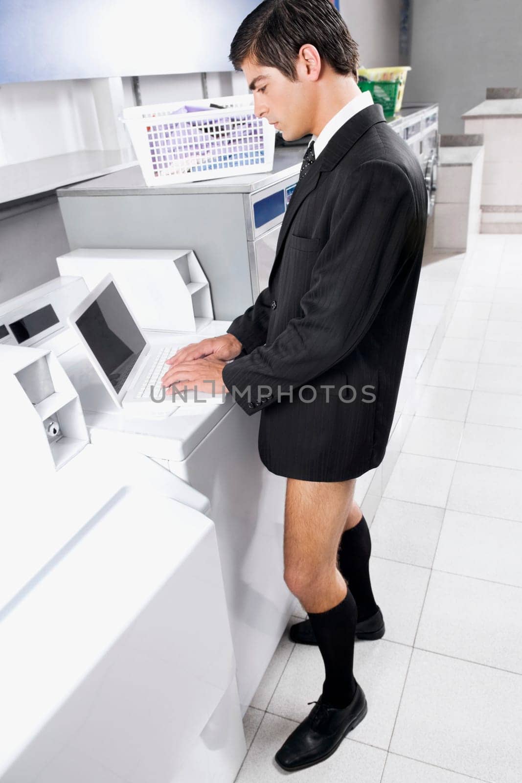Businessman working on a laptop in a laundromat