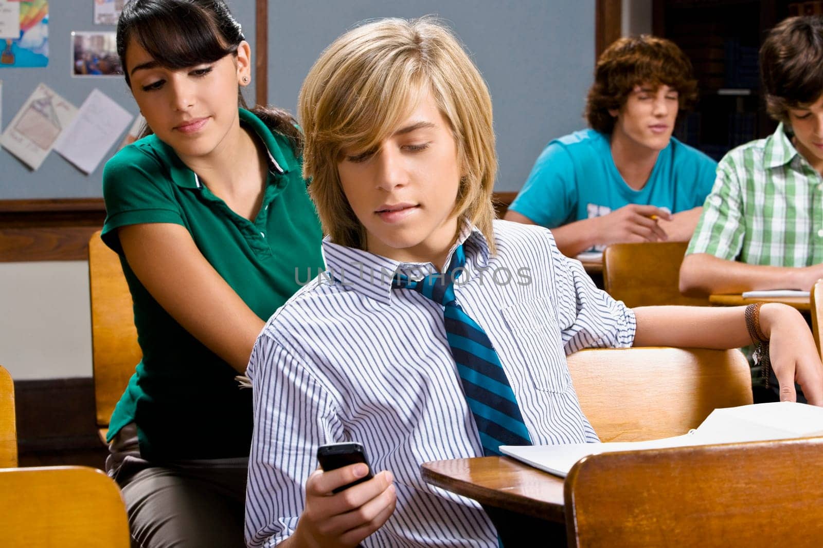 Teenage boy using a mobile phone in a classroom