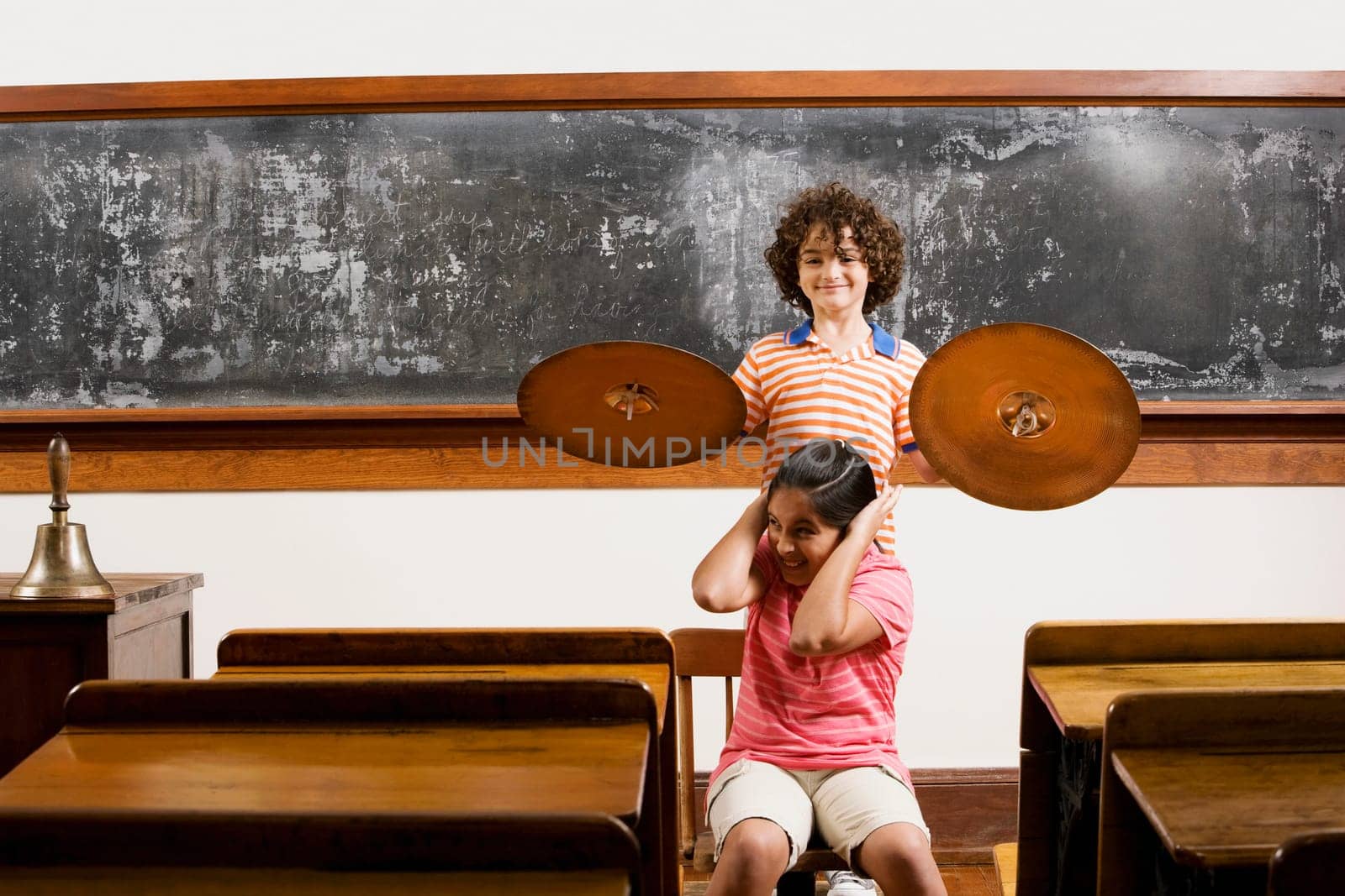 Two students having fun with cymbal in a classroom