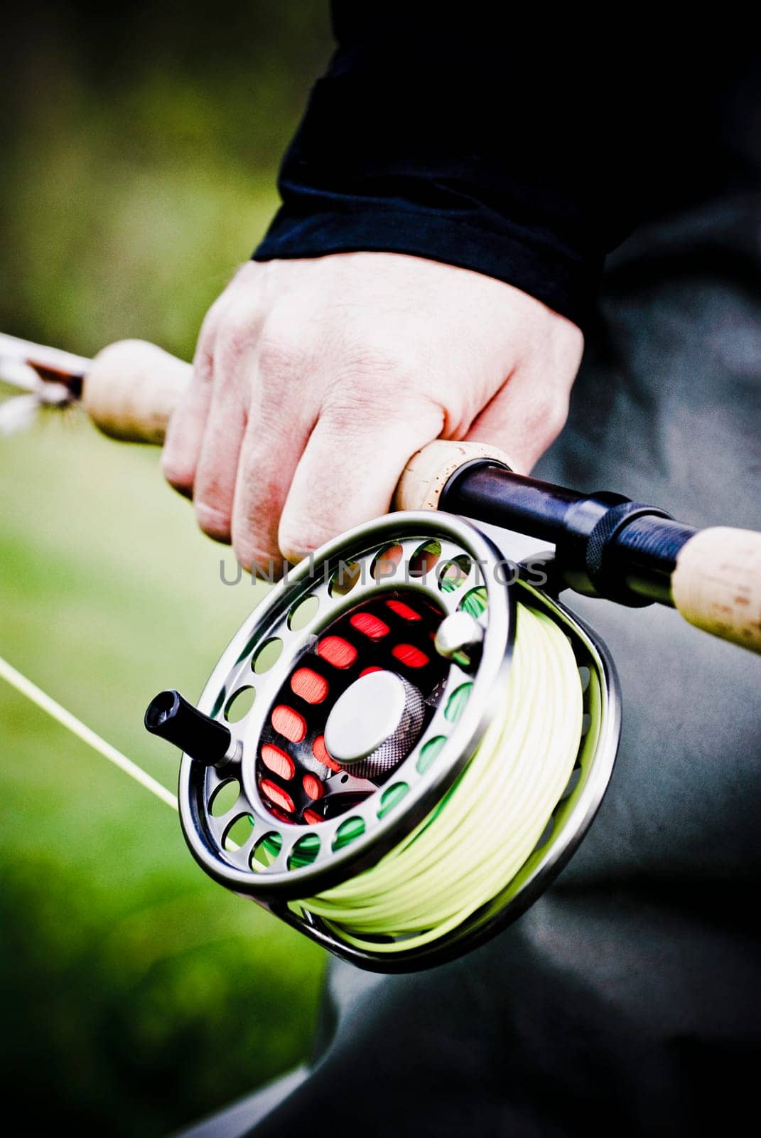 Mid section view of a person holding a fishing rod