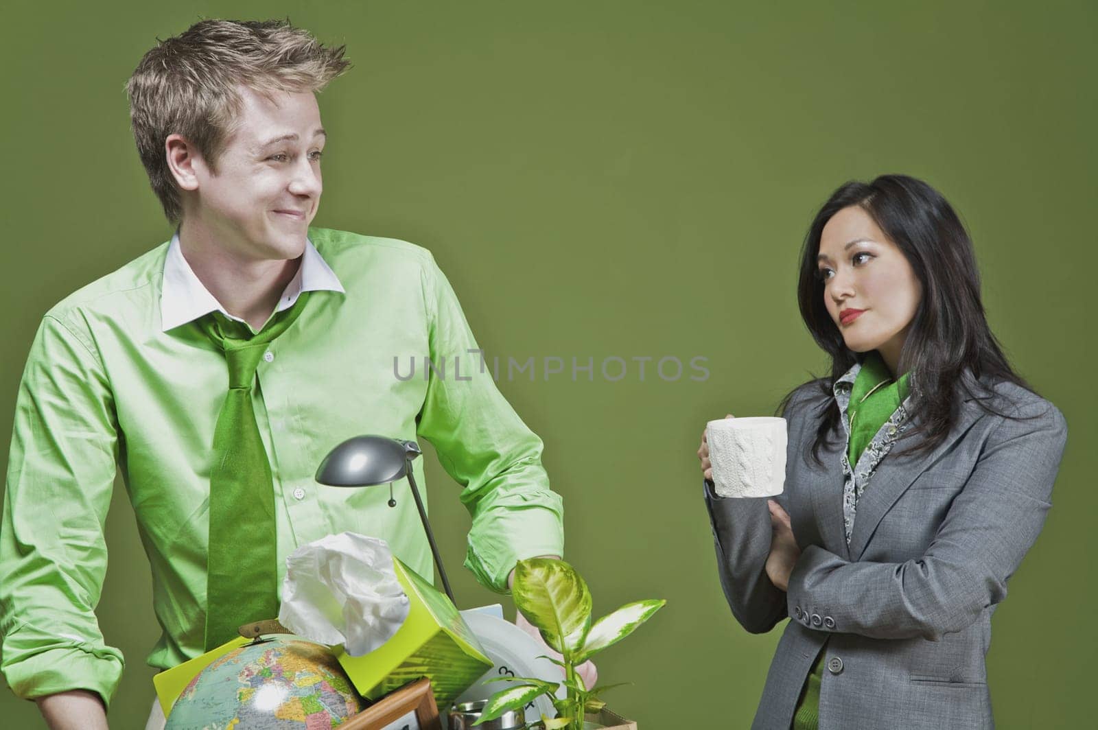 Businessman holding his belongings and a businesswoman holding a cup of coffee