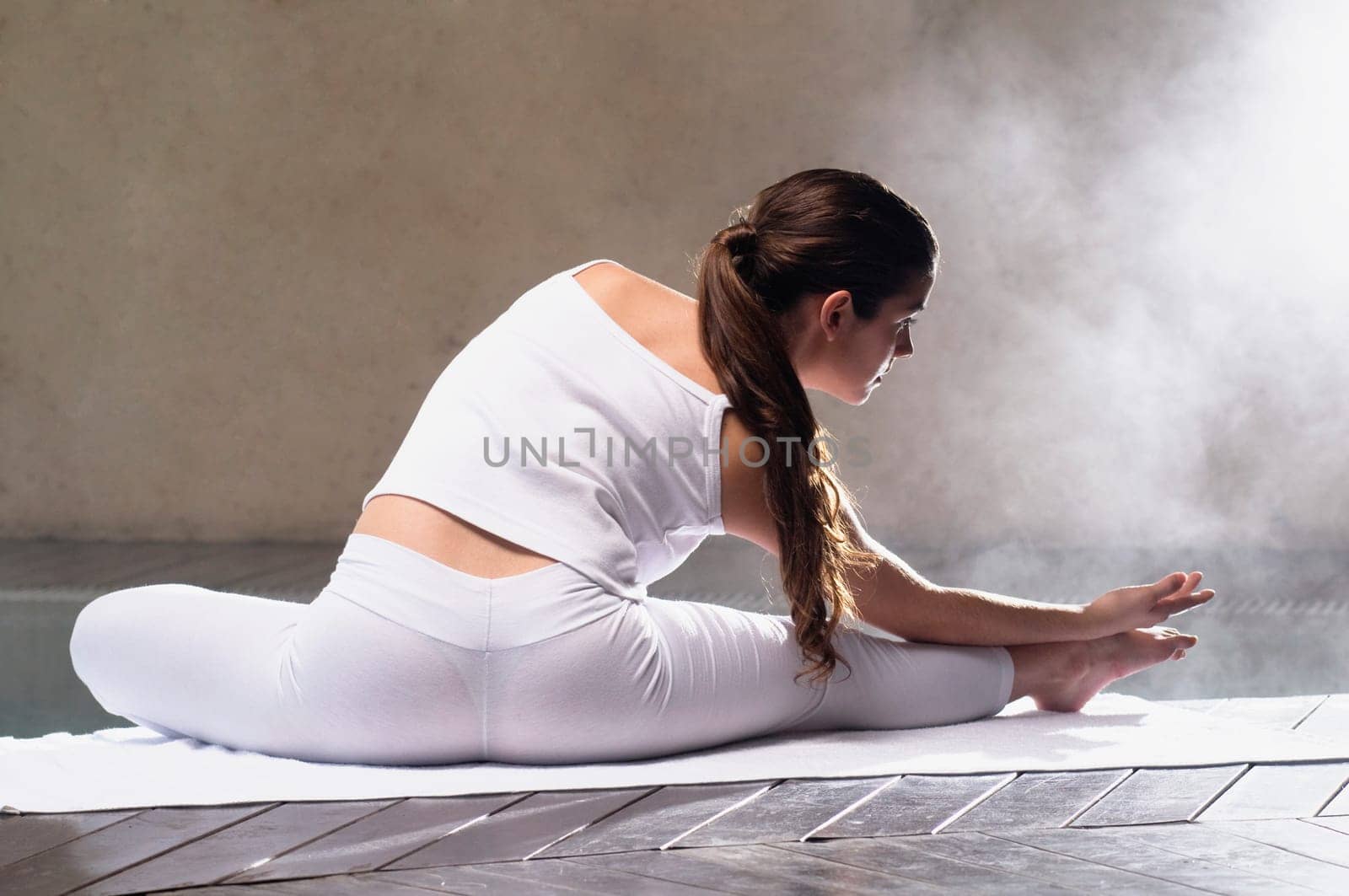 Young woman exercising at the poolside