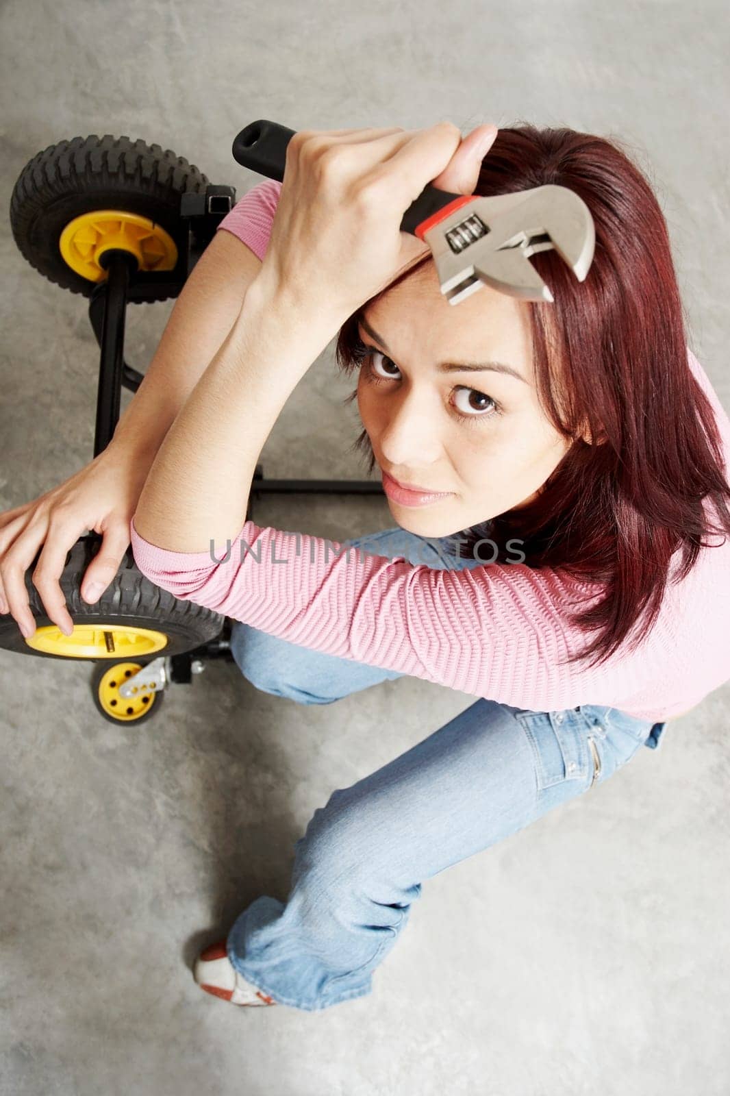 High angle view of a young woman holding a wrench