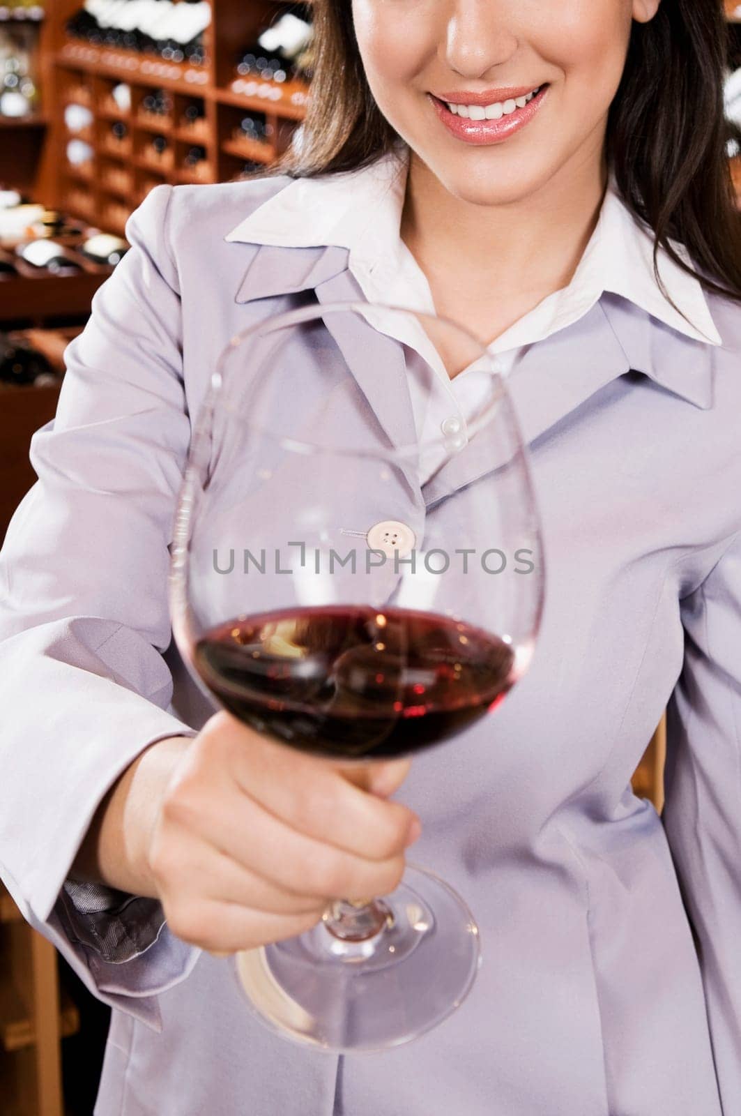 Businesswoman holding a glass of wine in a bar and smiling