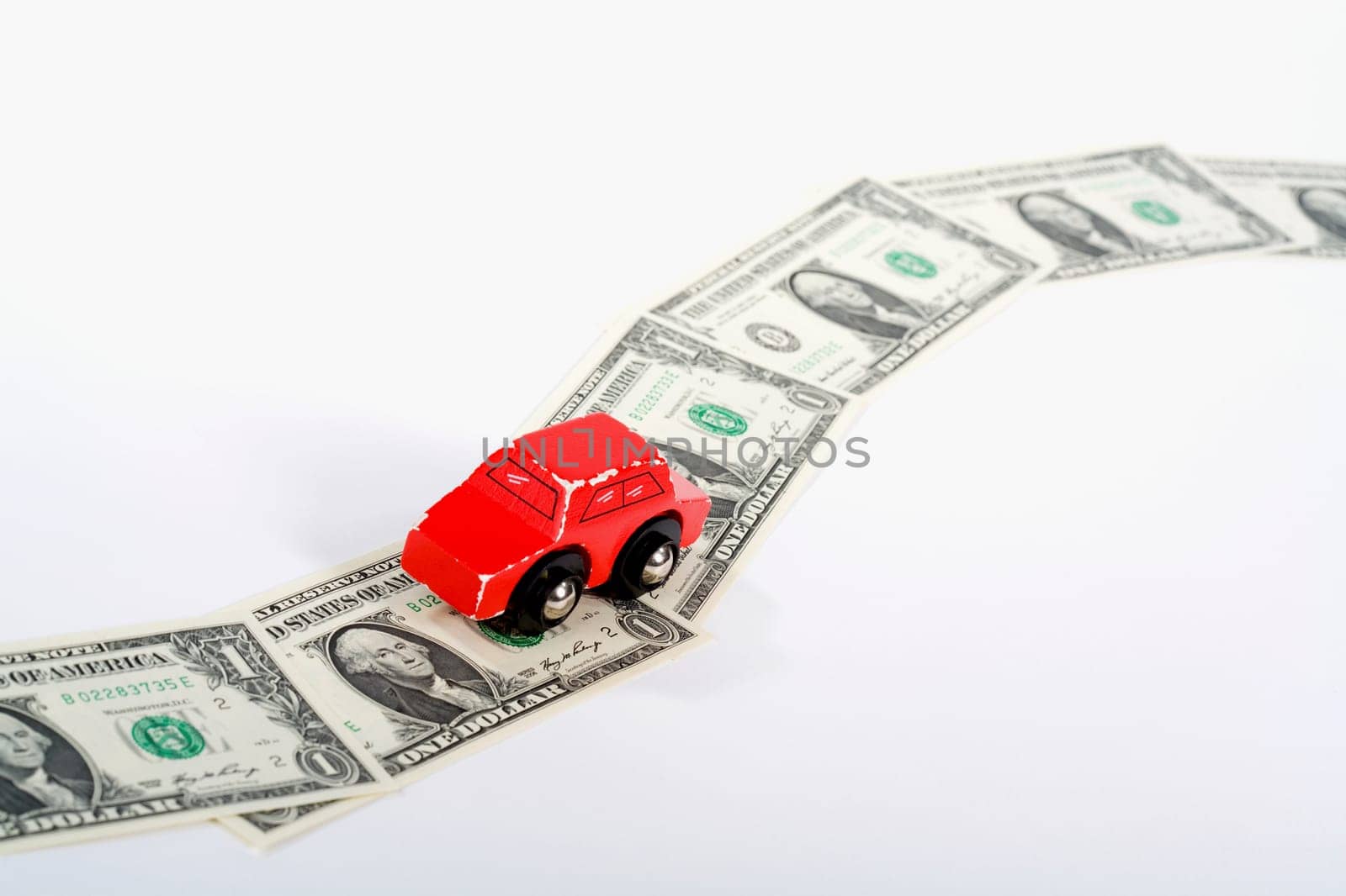 Toy car moving on a US paper currency road