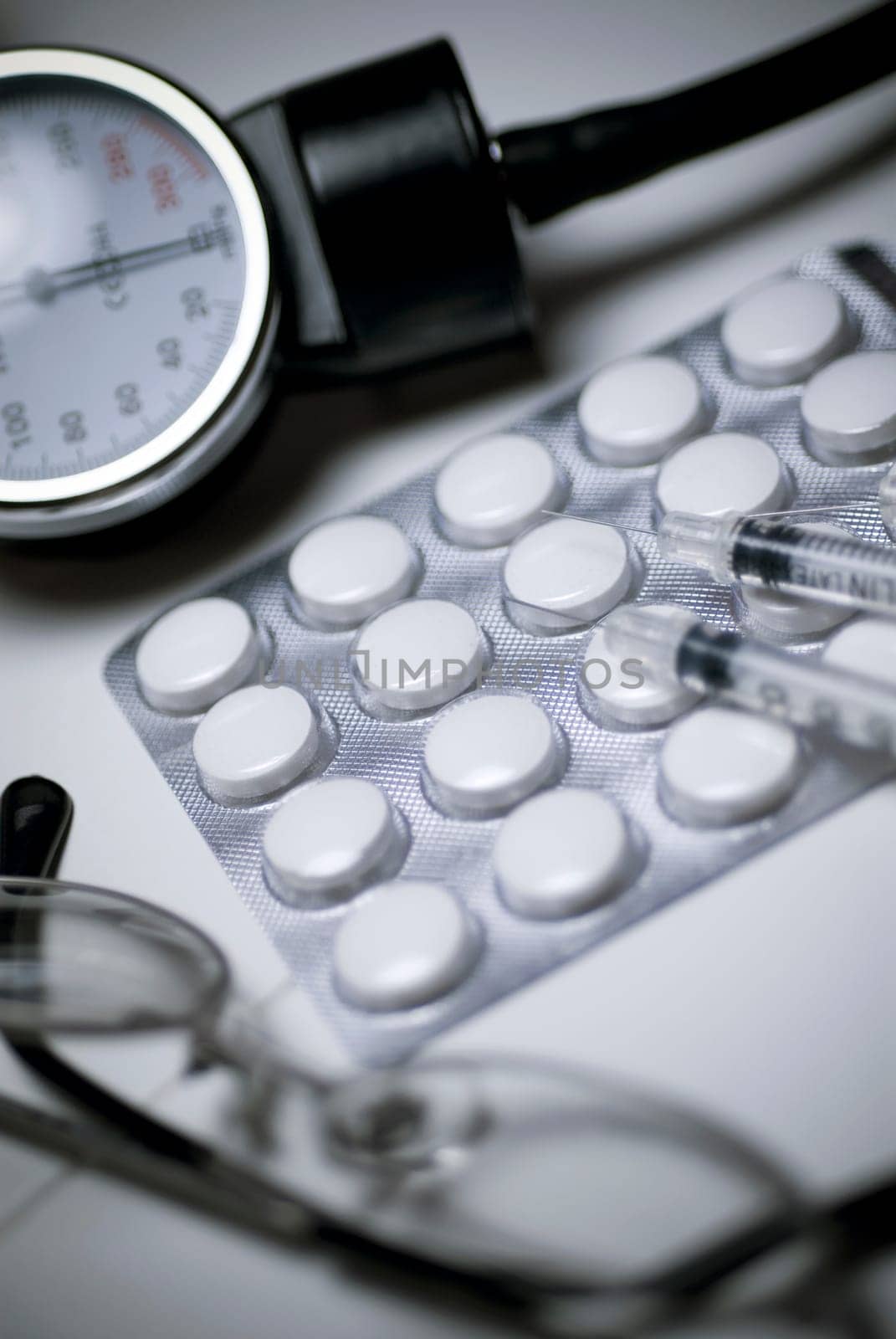 Close_up of eyeglasses and pills with medical equipments