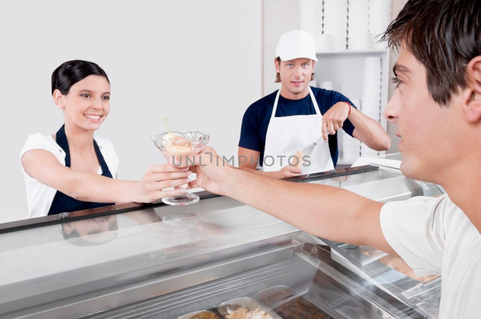 Female ice cream seller giving ice cream to a customer