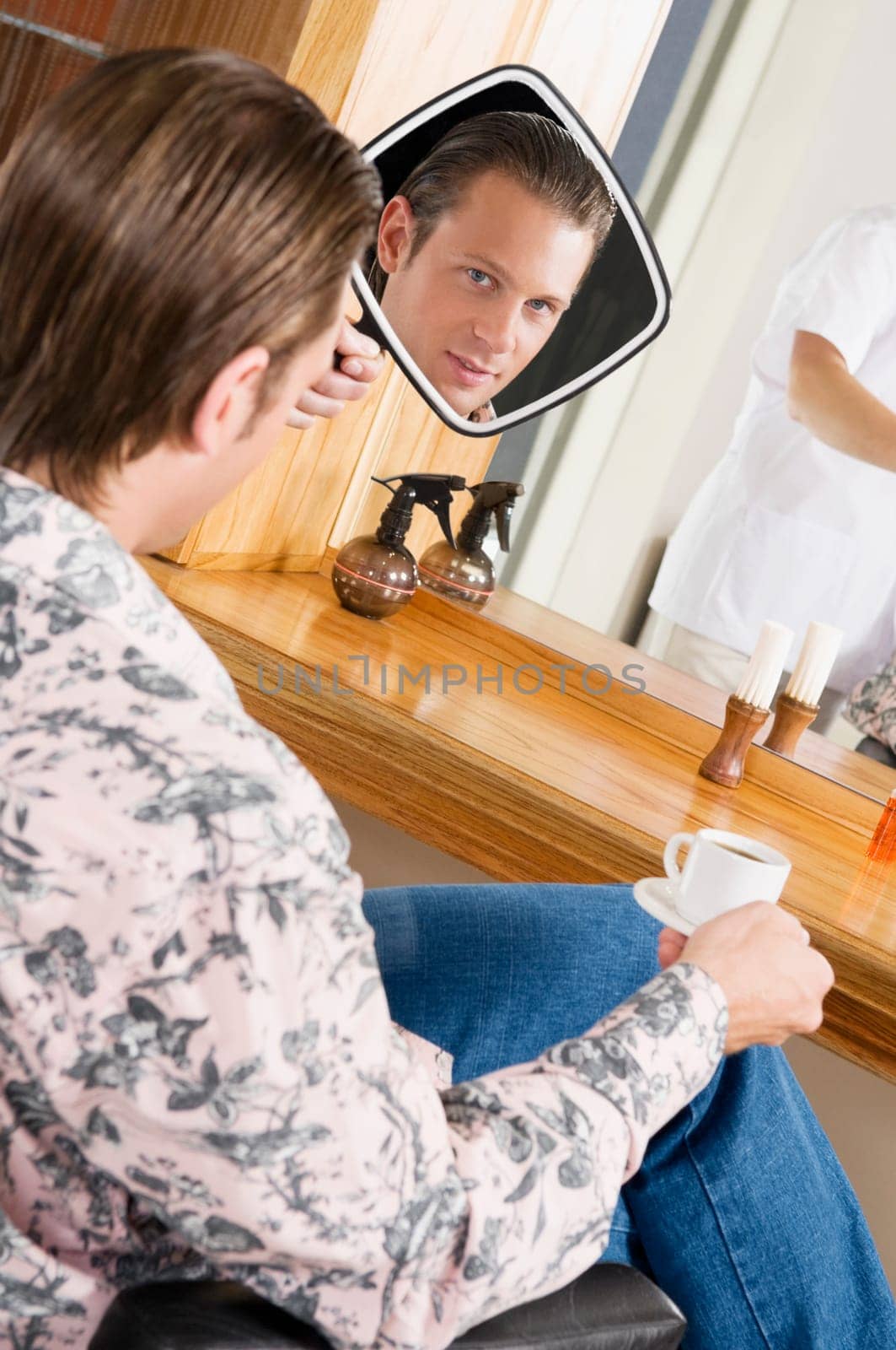 Man looking himself in a mirror after a haircut
