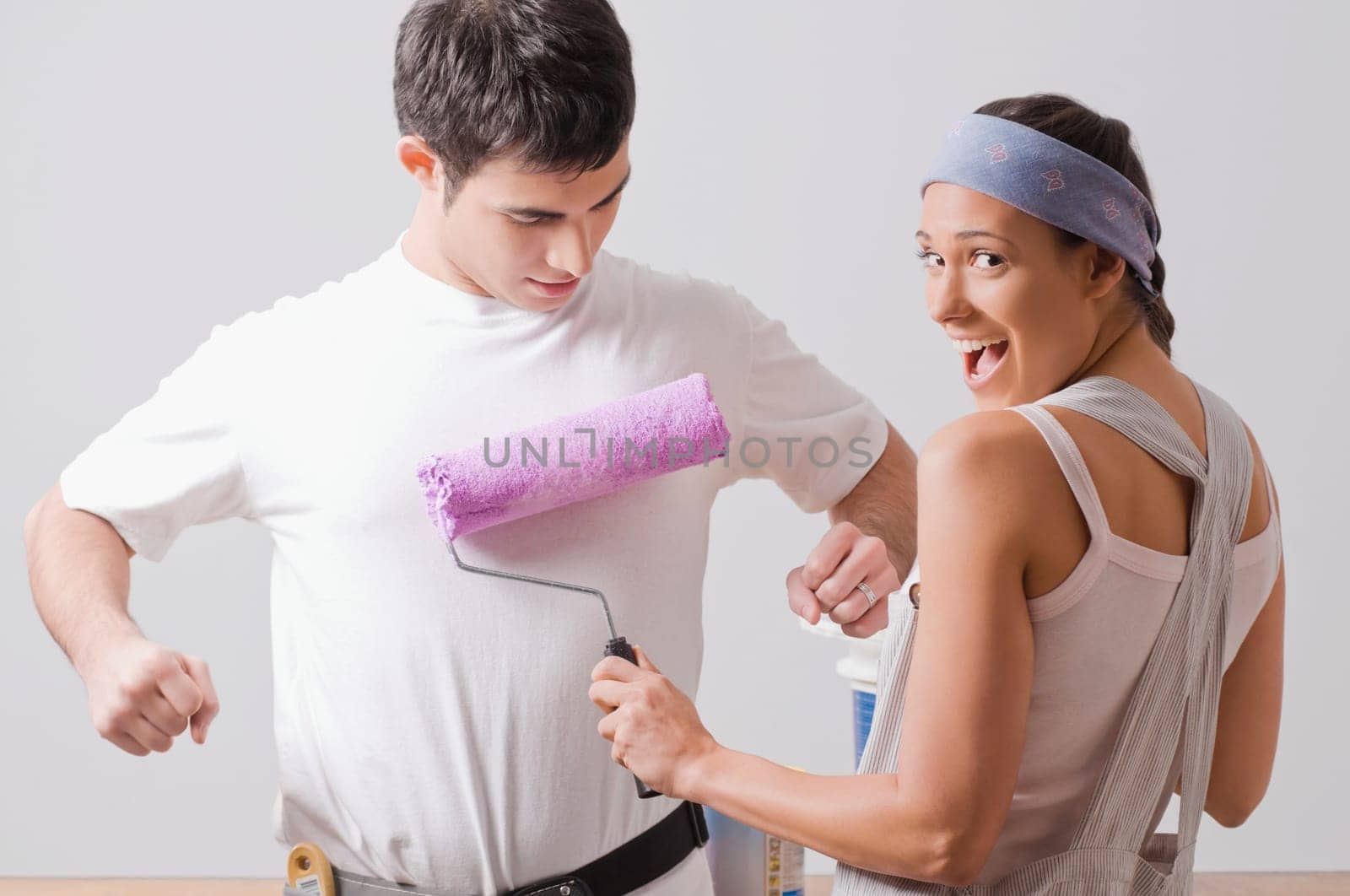 Portrait of a young woman painting on a young manŽs t_shirt and smiling