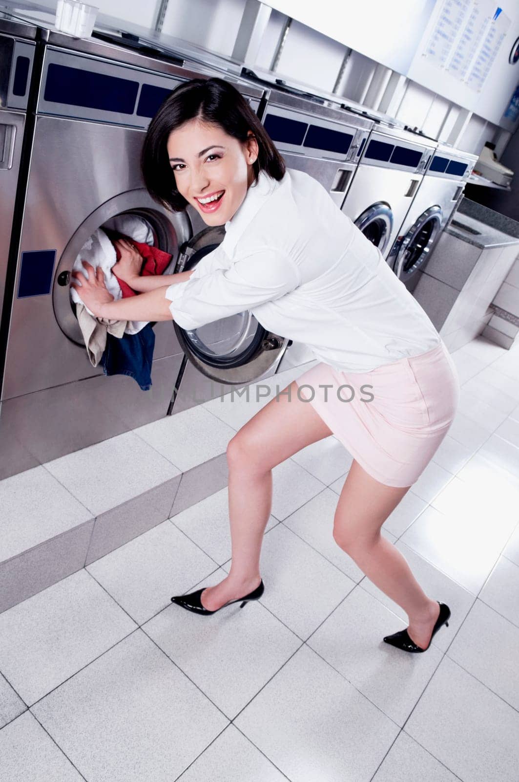 Woman putting clothes into a washing machine