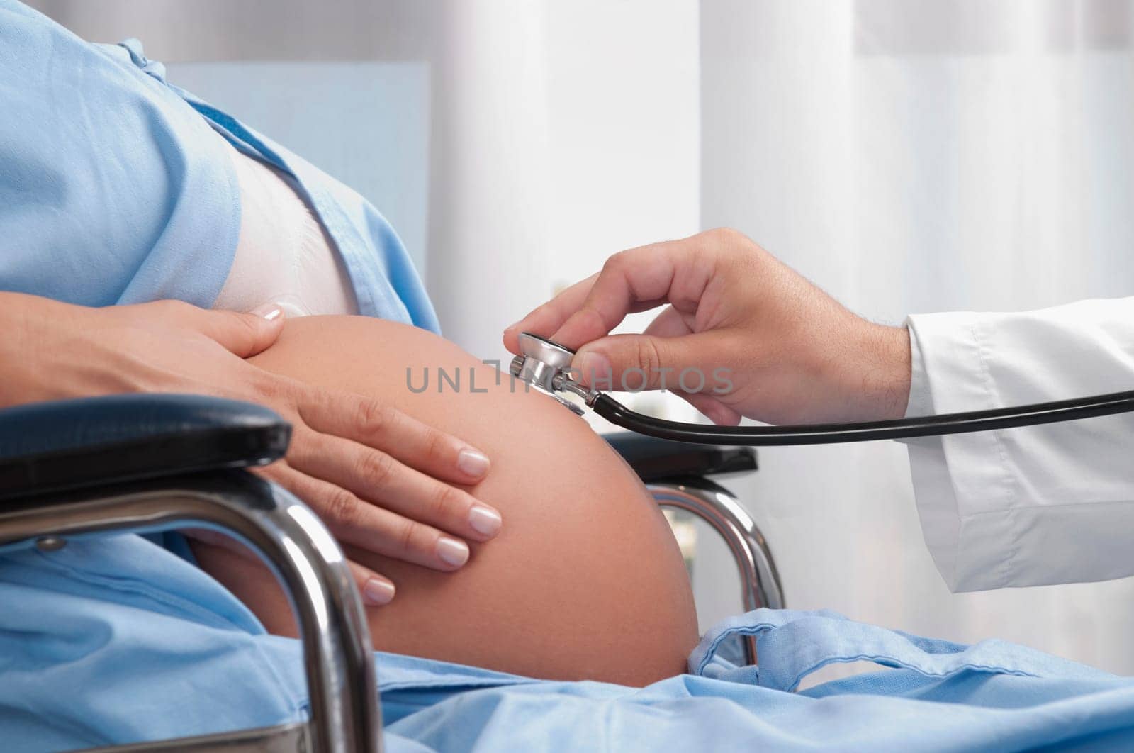 Doctor examining a pregnant woman with a stethoscope