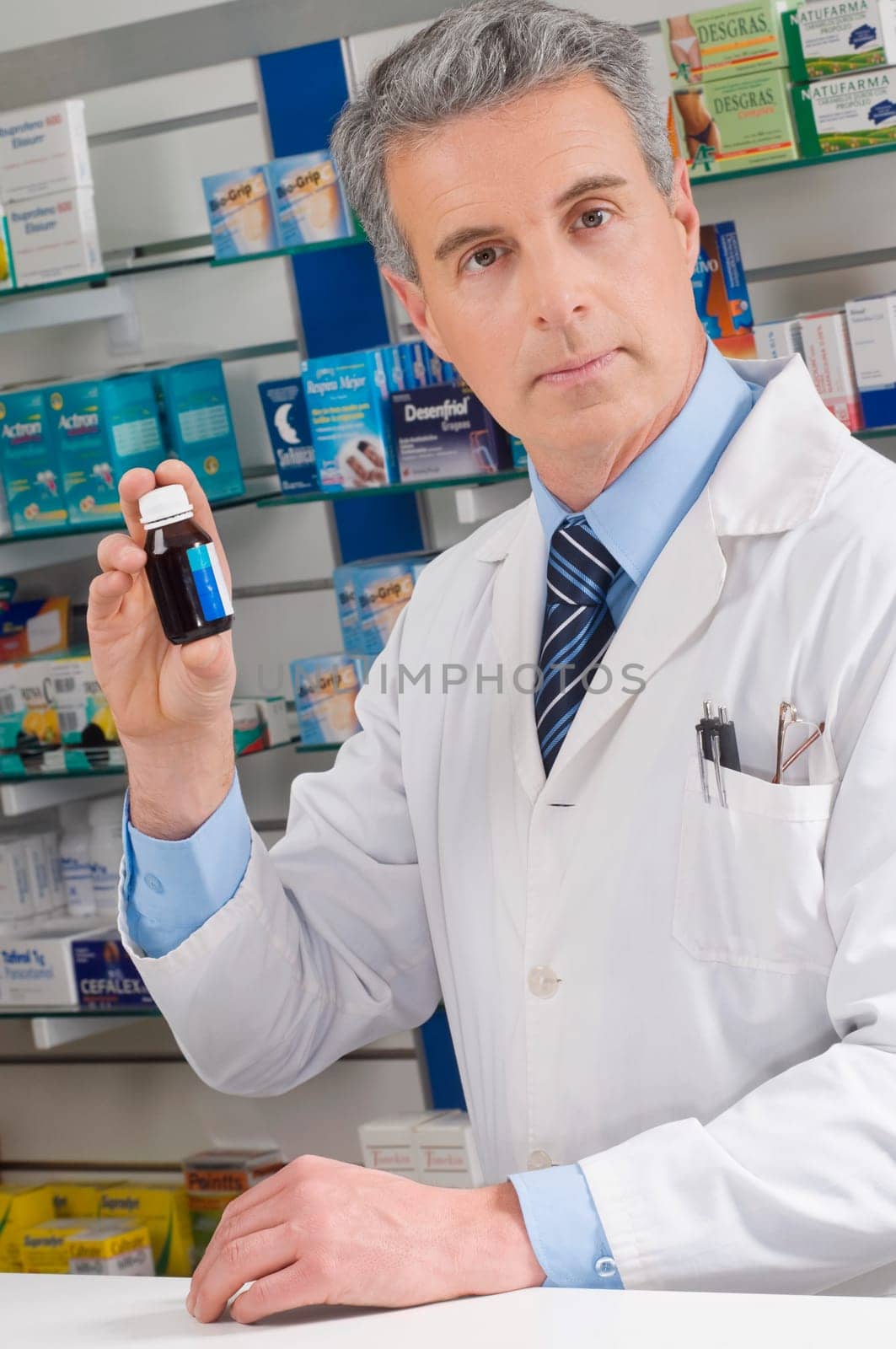 Male pharmacist holding a medicine bottle