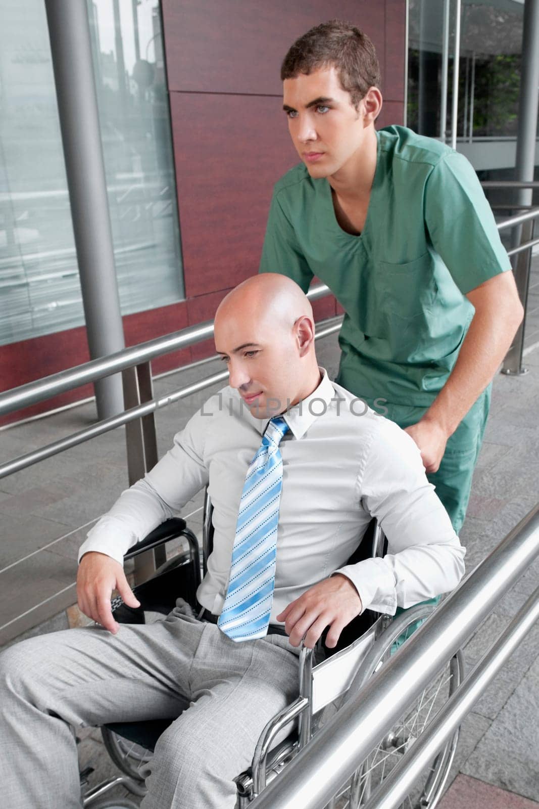 Male nurse pushing a man in wheelchair