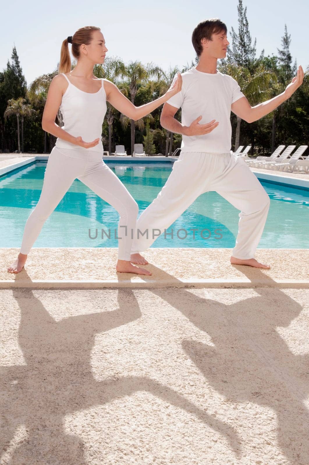 Couple exercising at the poolside