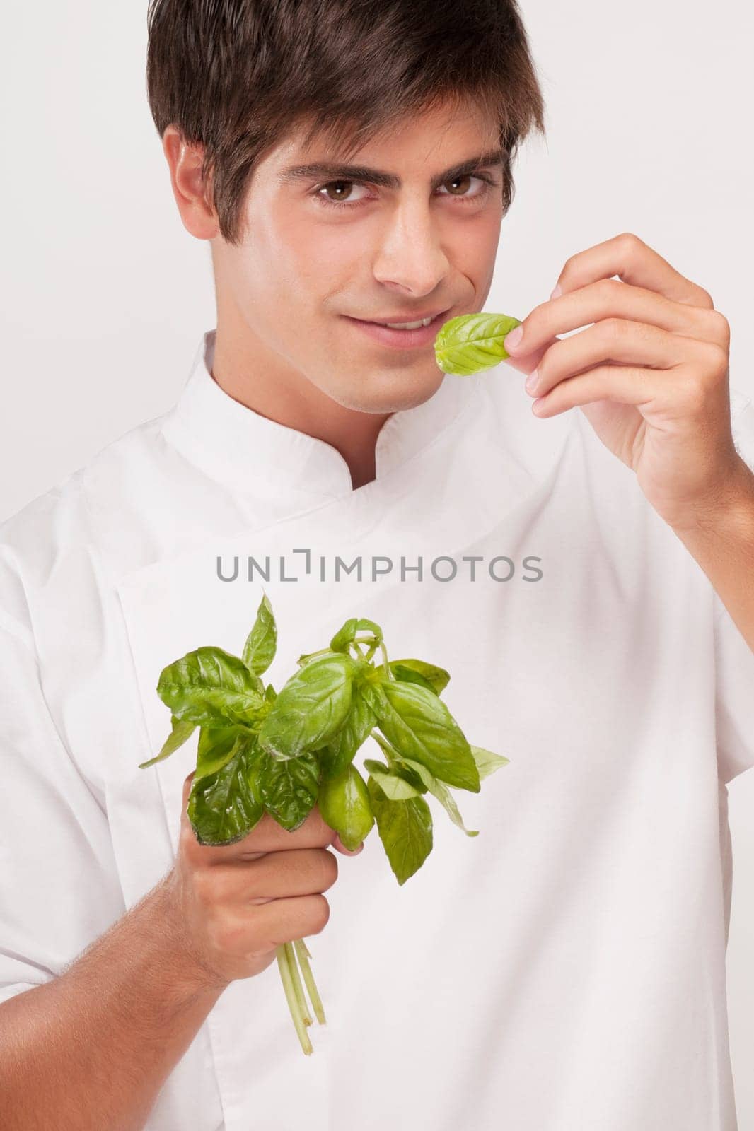 Man smelling basil leaves and smiling