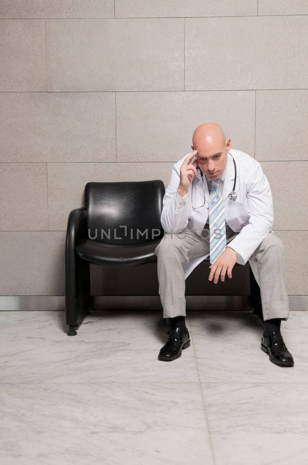 Doctor sitting on a chair and looking stressed
