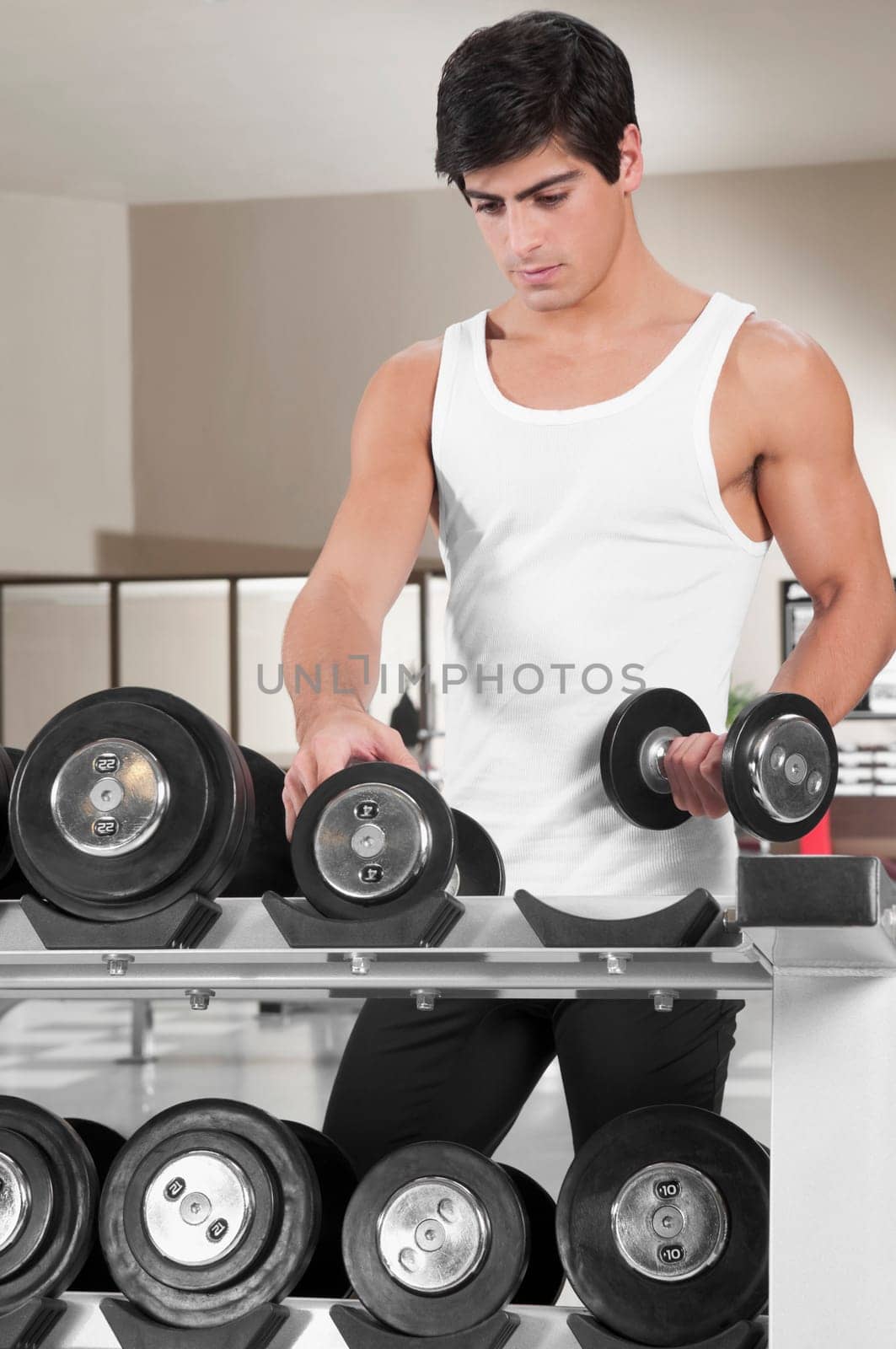 Man picking up dumbbells in a gym
