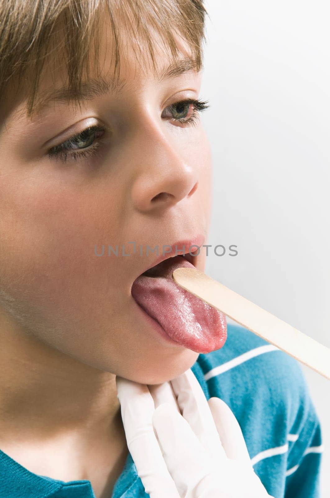 Doctor examining a boyŽs mouth with a tongue depressor