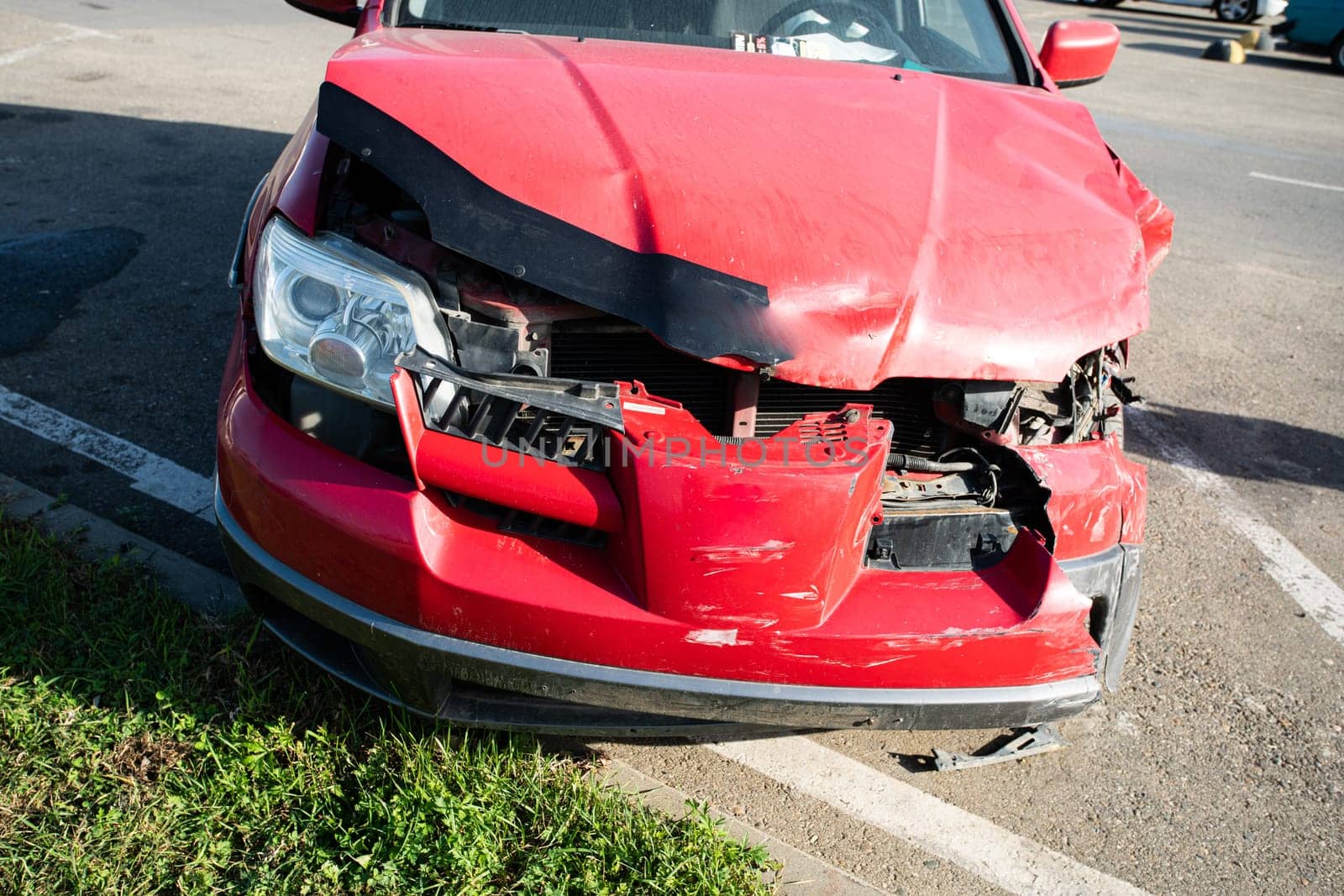 Front of red car get damaged by accident on the road