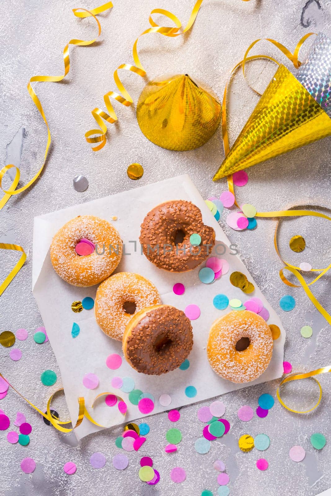 Donuts for carnival and party. Donuts with streamers and confetti. Colorful carnival or birthday image.