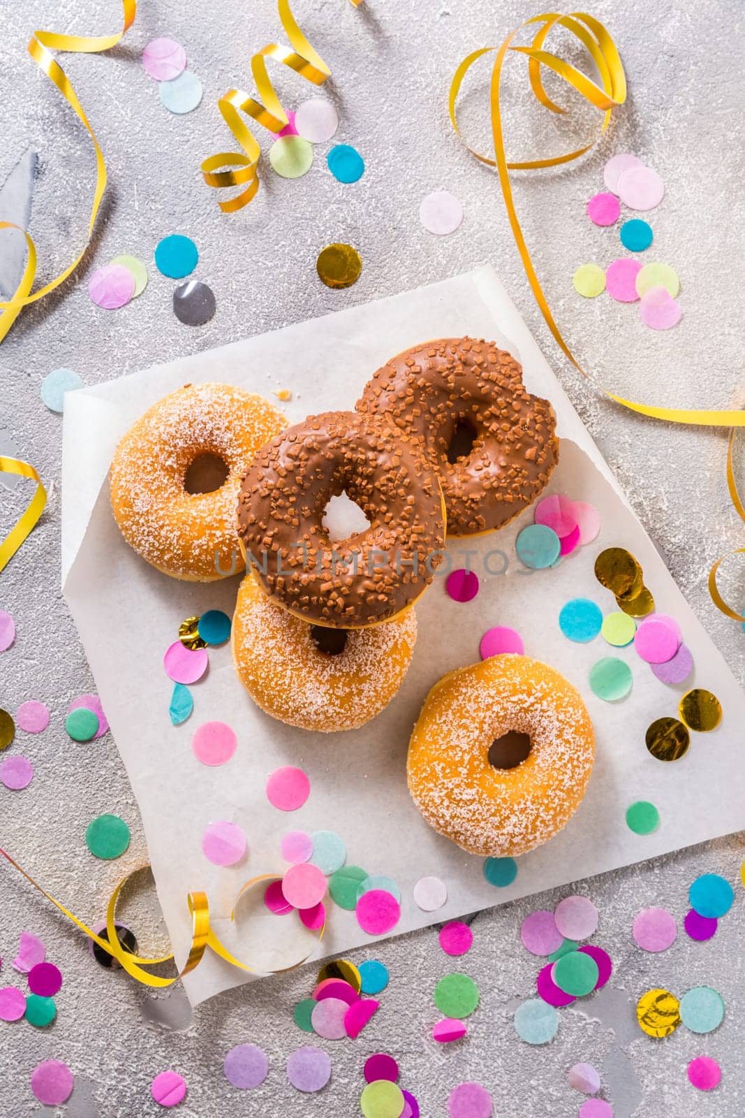Donuts for carnival and party. Donuts with streamers and confetti. Colorful carnival or birthday image.