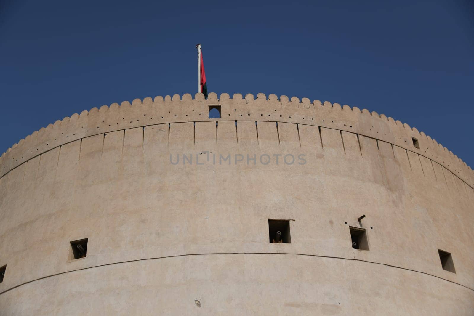 The large fortress Fort Nizwa is located on the edge of the Hajar Mountains in the oasis city in Oman. You can see the largest tower of a fortress in Oman.