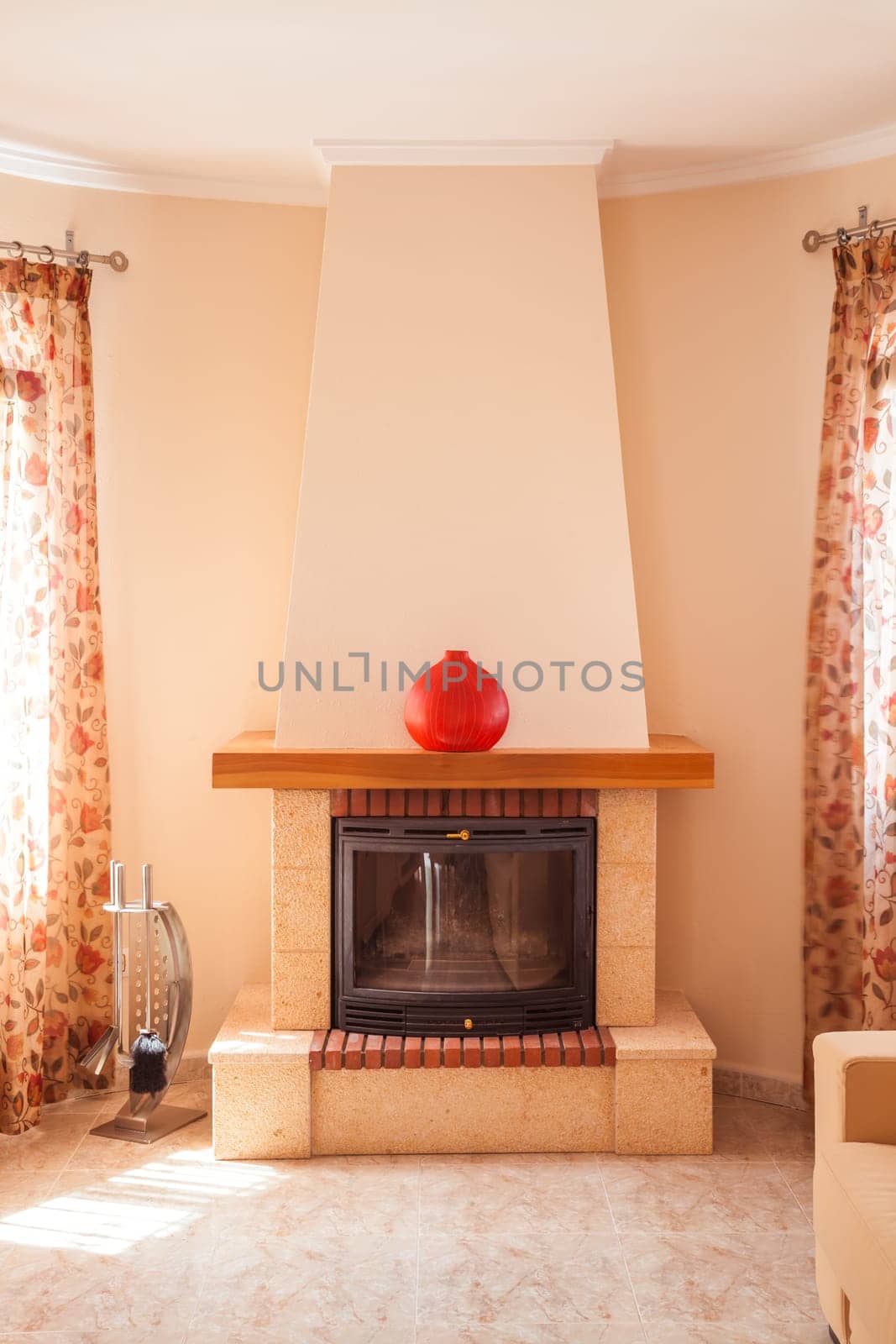 Concept of fireplace with fire at home. Comfortable living room in Mediterranean style