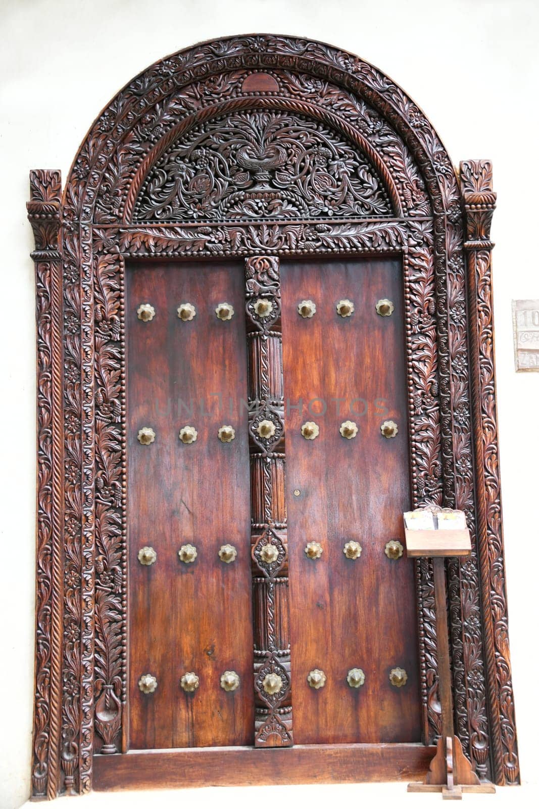 The famous and historic Indian style front doors adorn many houses in Stone Town on the island of Zanzibar. The Indian doors have a domed frame and brass tips.