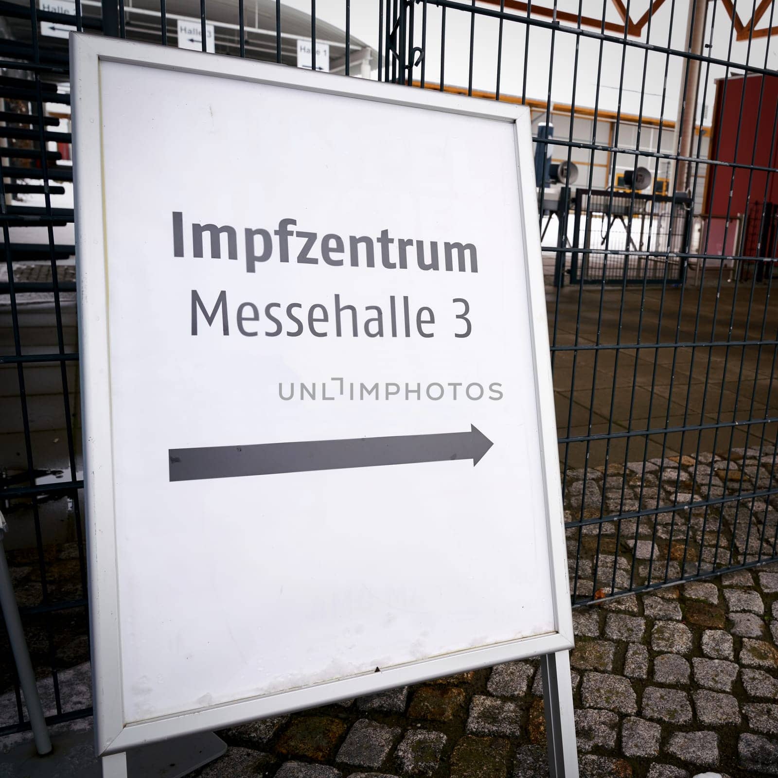 Directional arrow to a vaccination center on the outskirts of the city of Magdeburg in Germany. Sign with the inscription vaccination center (Impfzentrum) in exhibition hall 3