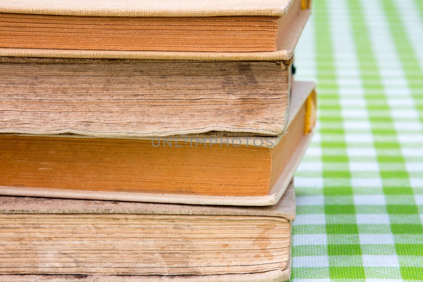 Old books stacked on top of one another, with a checkered background