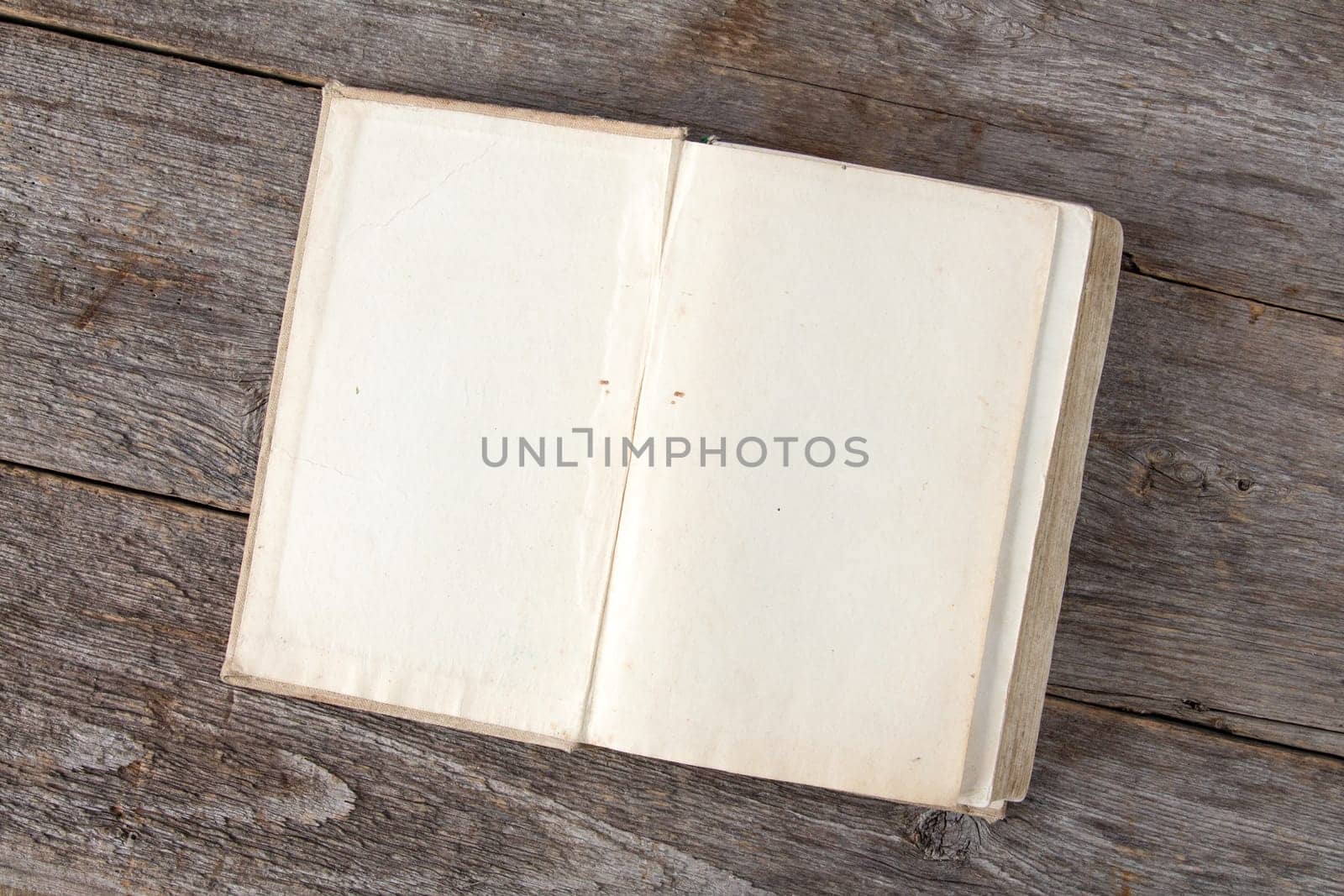 Open vintage book on old wooden background, with copy-space