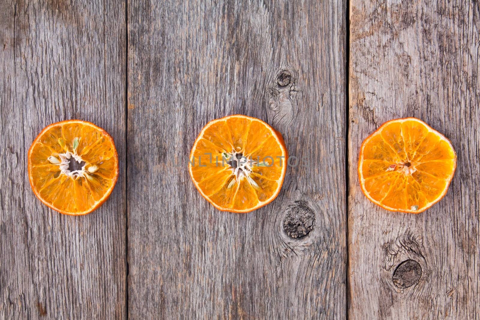 Three orange slices on a wooden background. The benefits of fruit.
