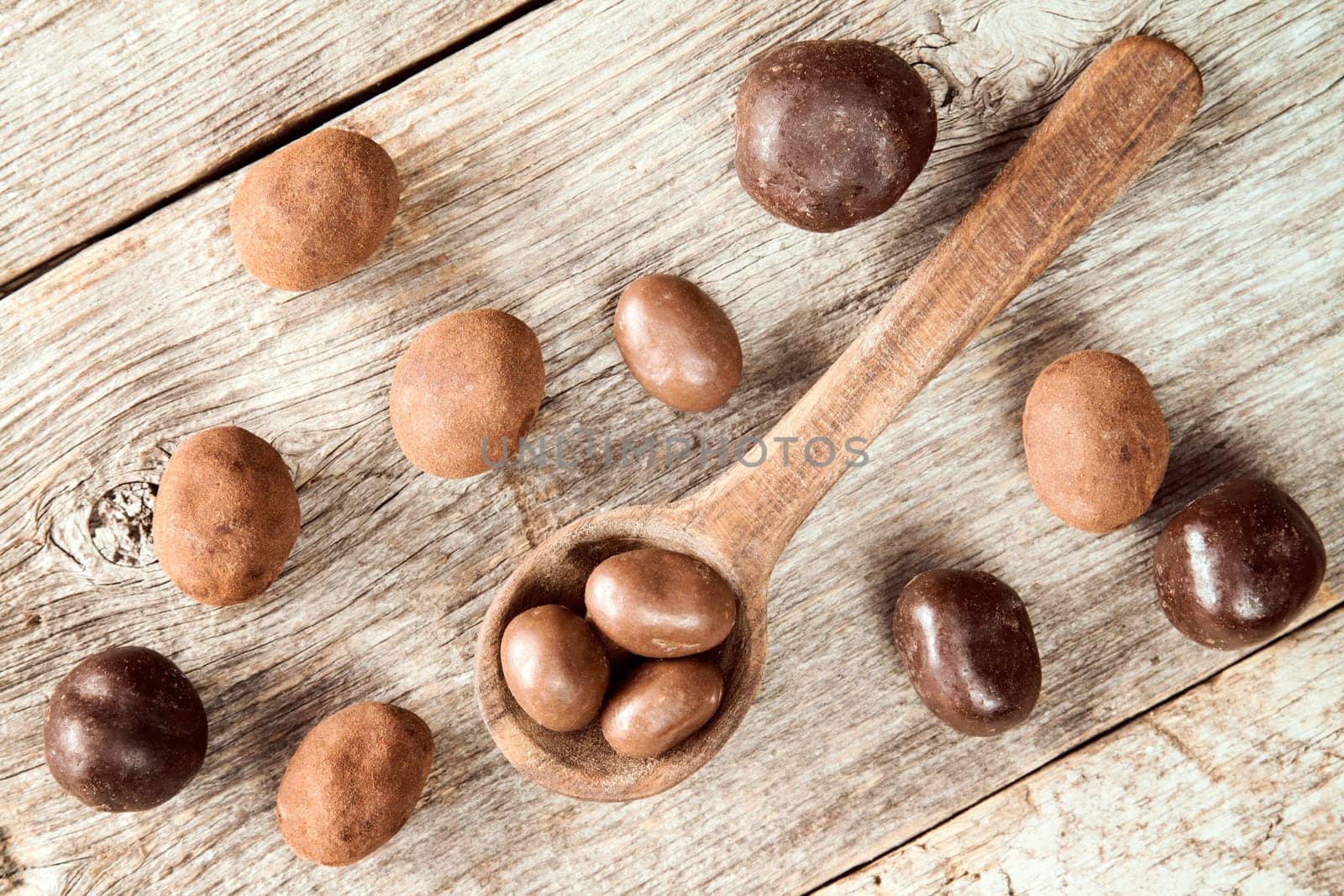 Sweet chocolate balls and small wooden spoon.Top view.