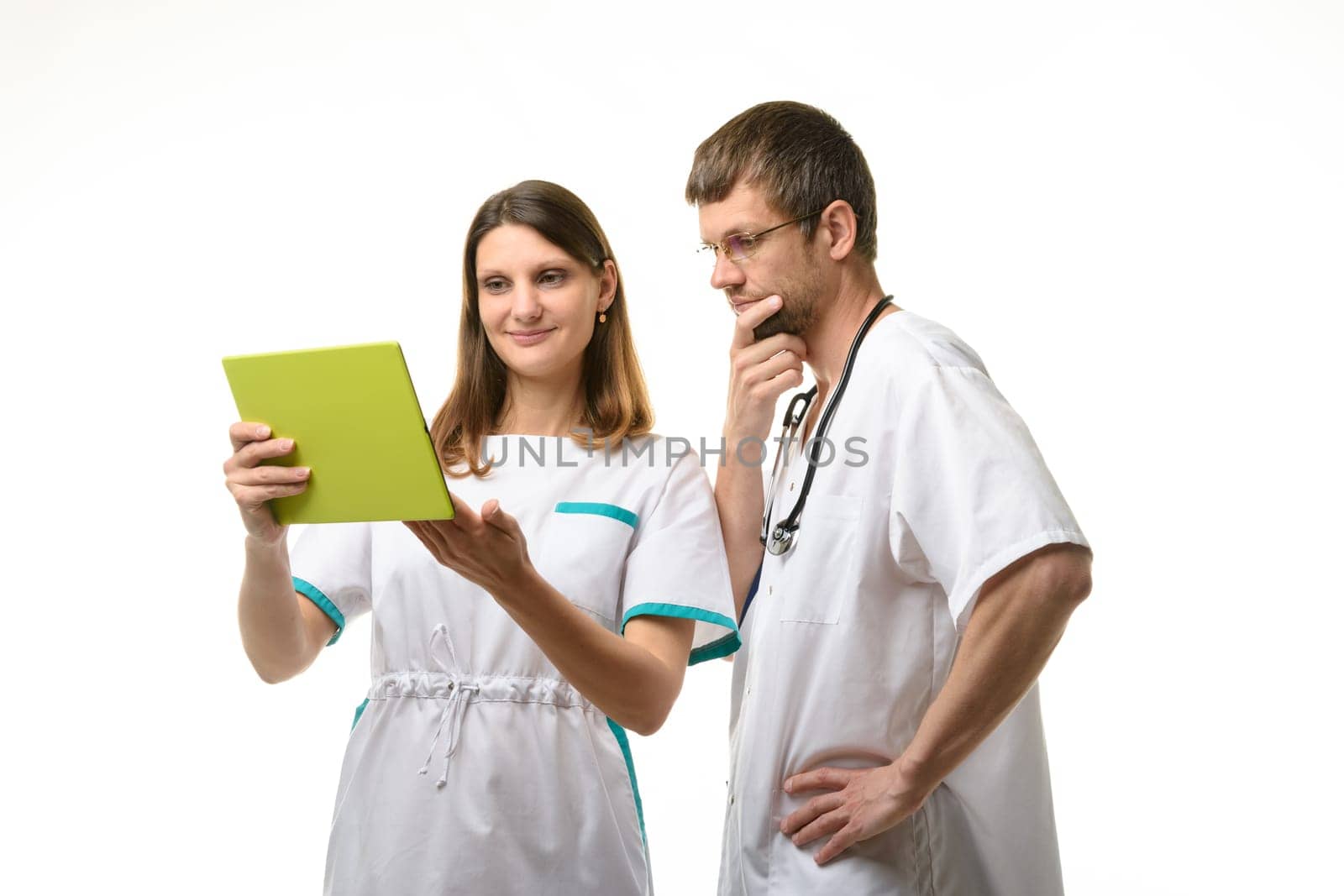 The nurse shows the test results in a tablet computer, the doctor looks thoughtfully at the screen
