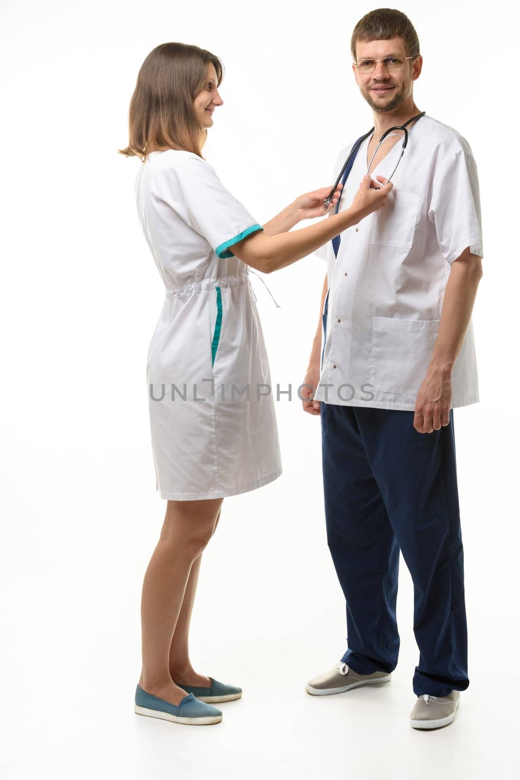 The nurse adjusts the phonendoscope on the neck of the doctor