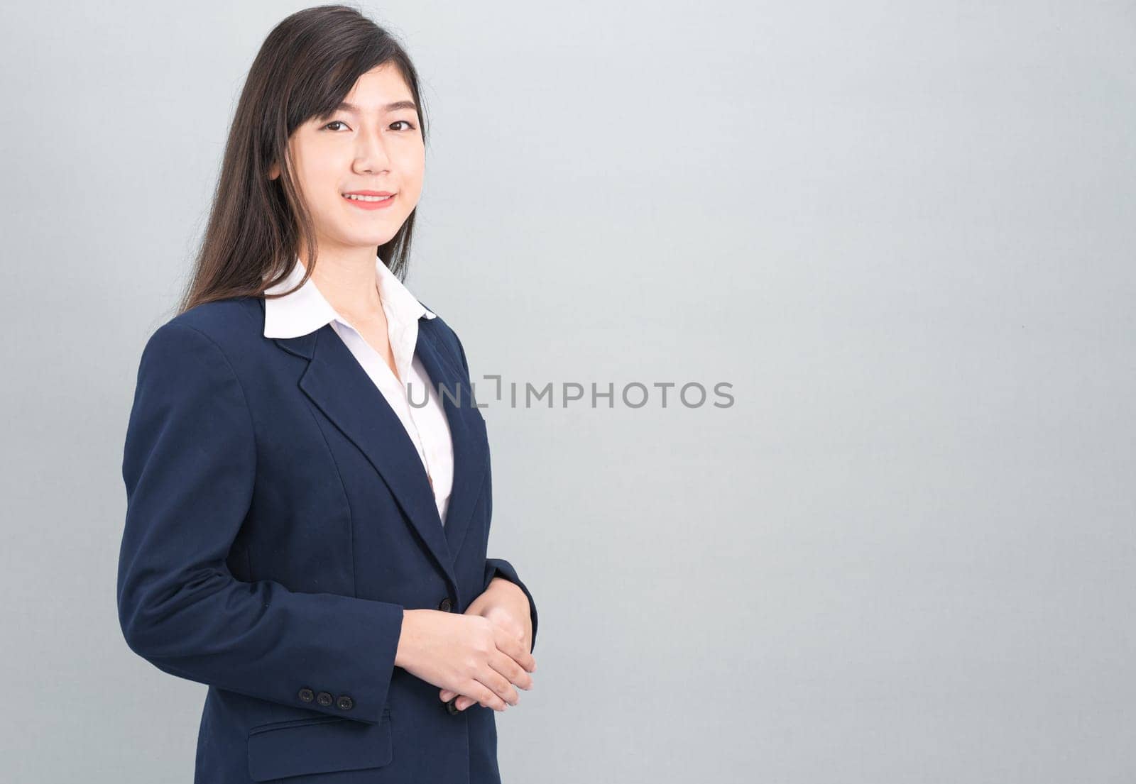 Portrait of asian business woman standing isolated on gray background