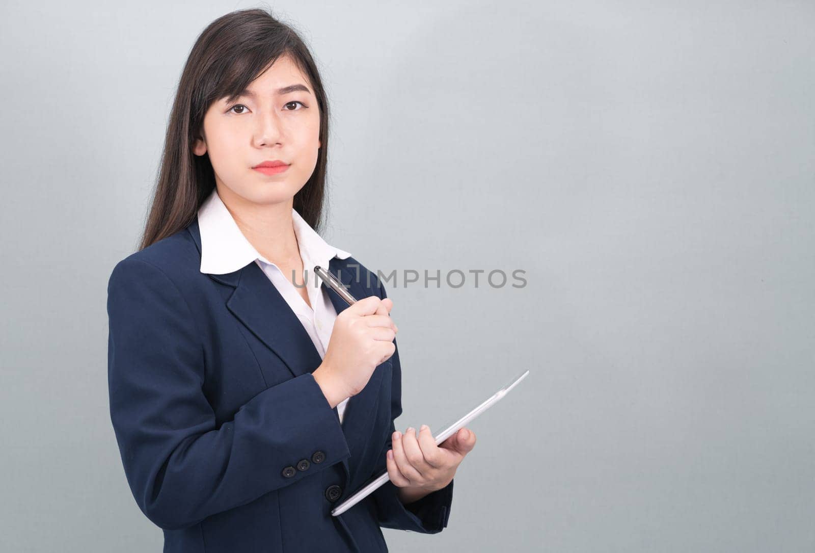 Woman in suit using computer digital tablet isolate on gray background