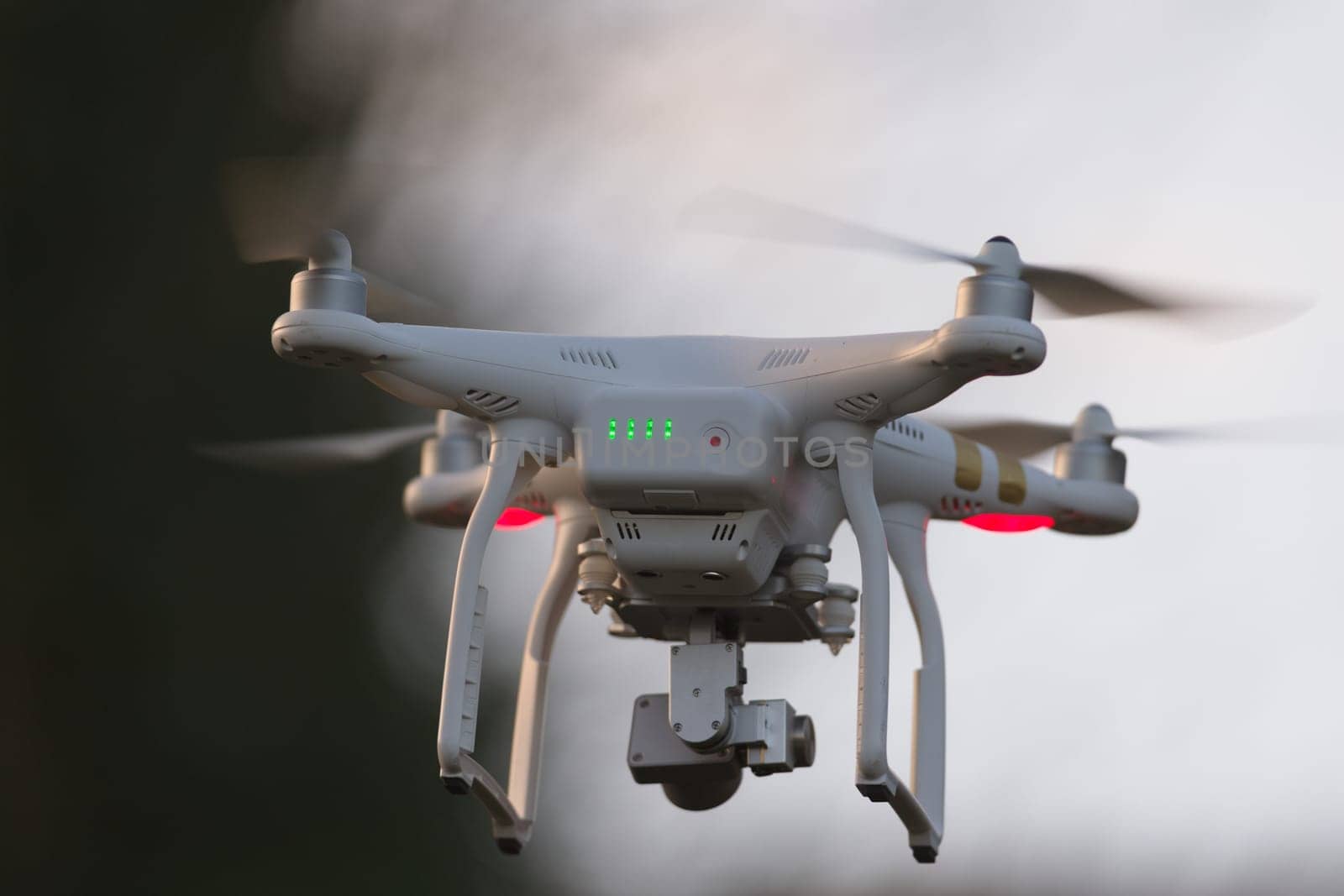 Great Malvern, United Kingdom, 27th December, 2020: Drone quadcopter hovering in front of trees and blue sky, selective focus blurs the background