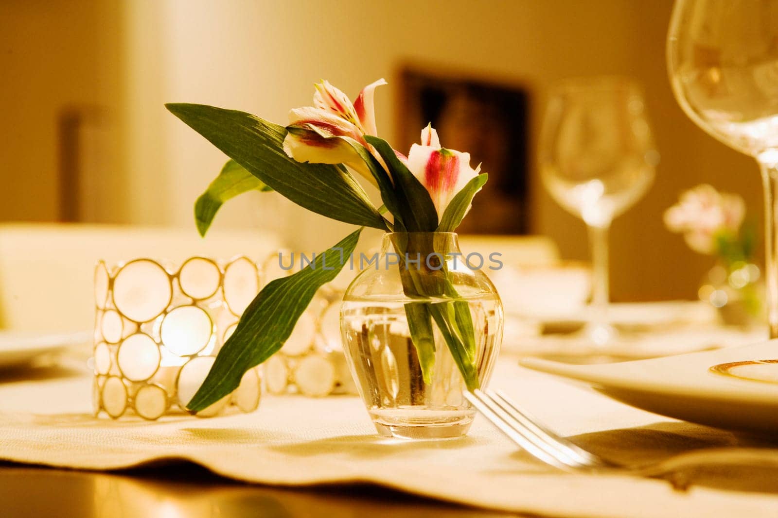 Close-up of a flower vase with candlestick holders on a dining table