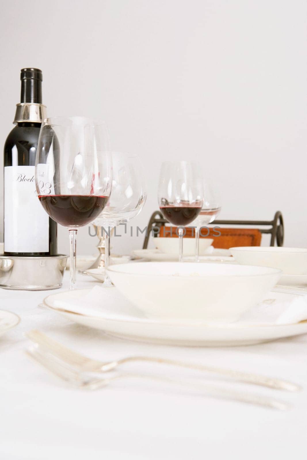 Wine bottle and wine glasses with tableware on a dining table