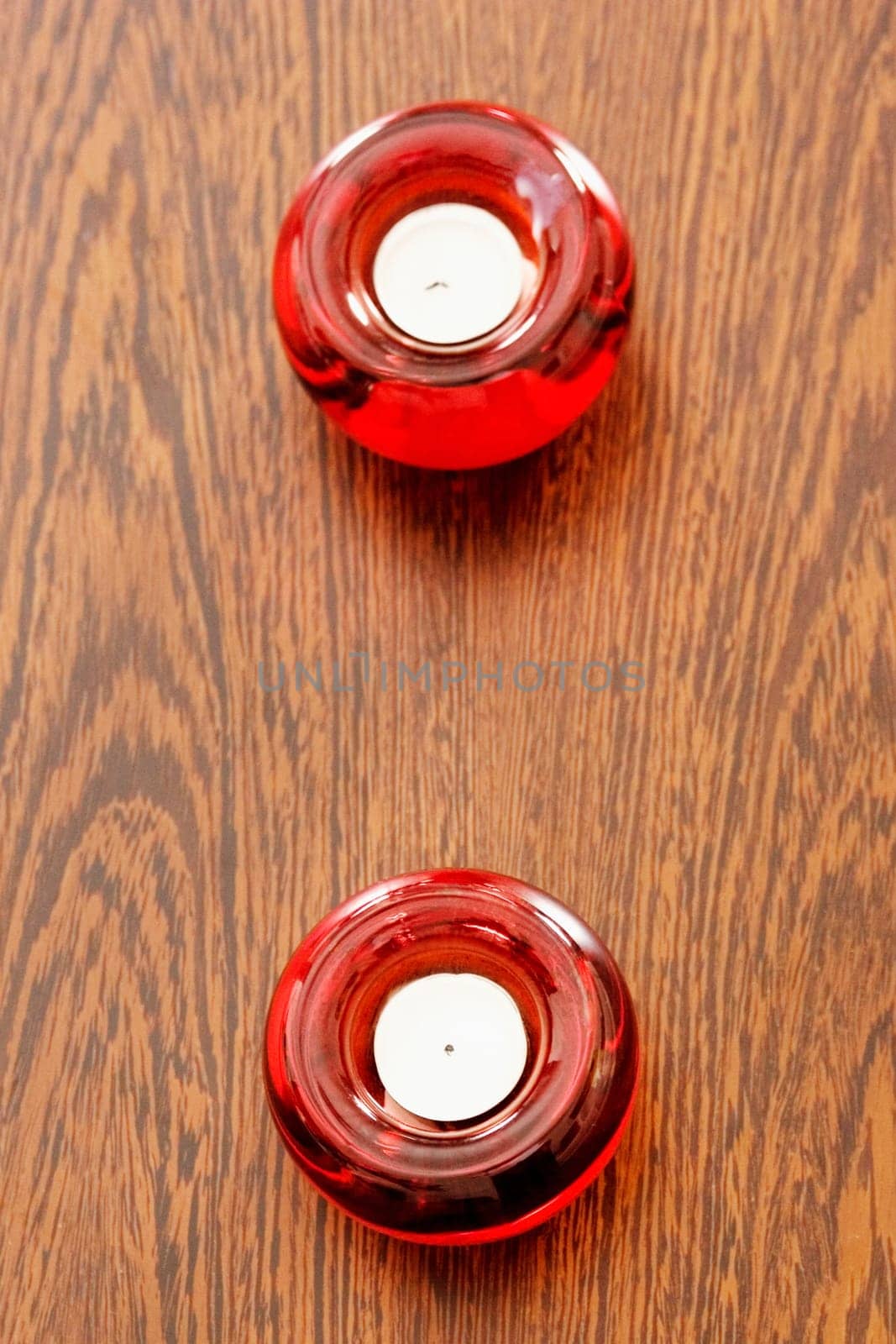 High angle view of two candles in candlestick holders on a table