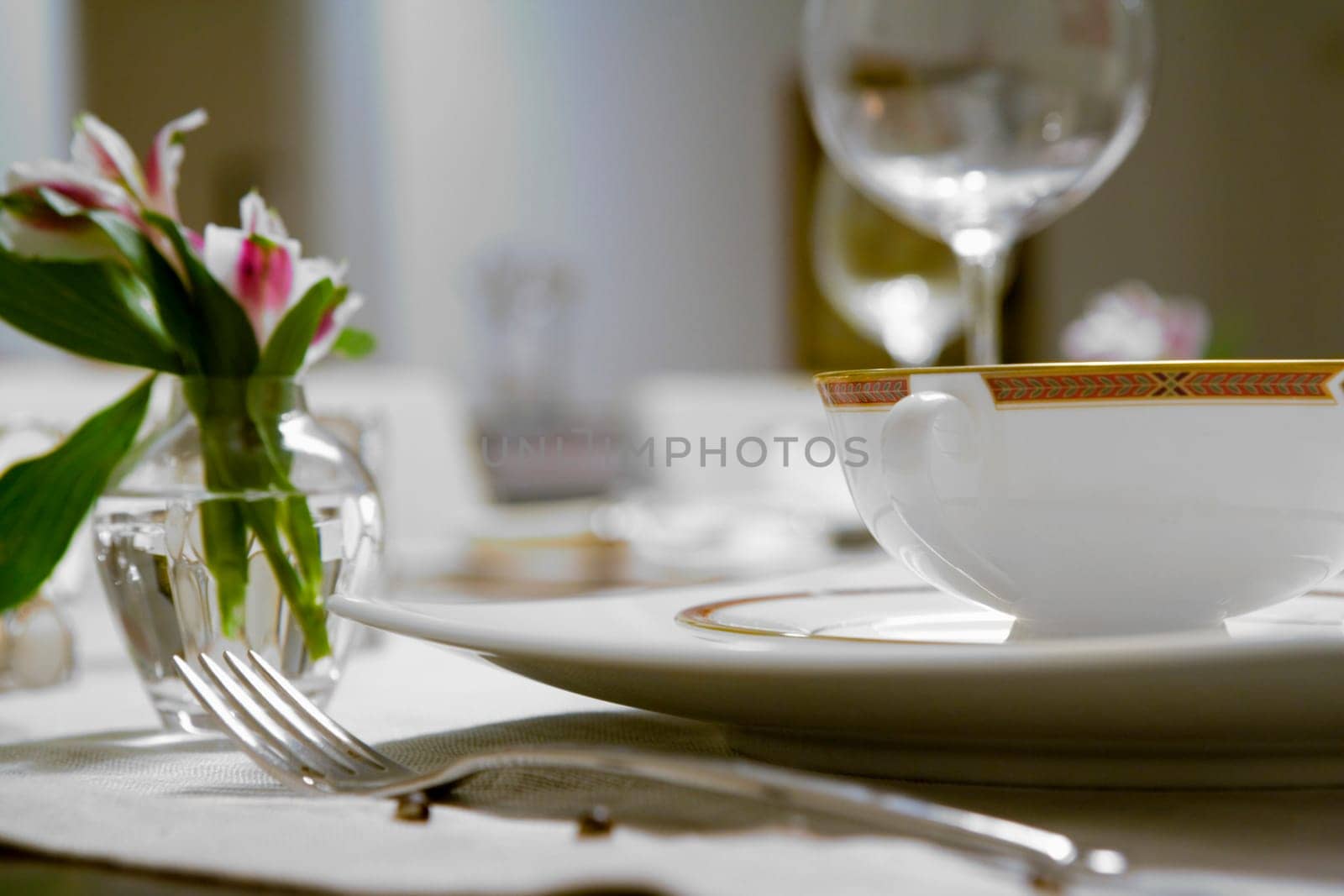 Close-up of a flower vase and a soup bowl on a dining table