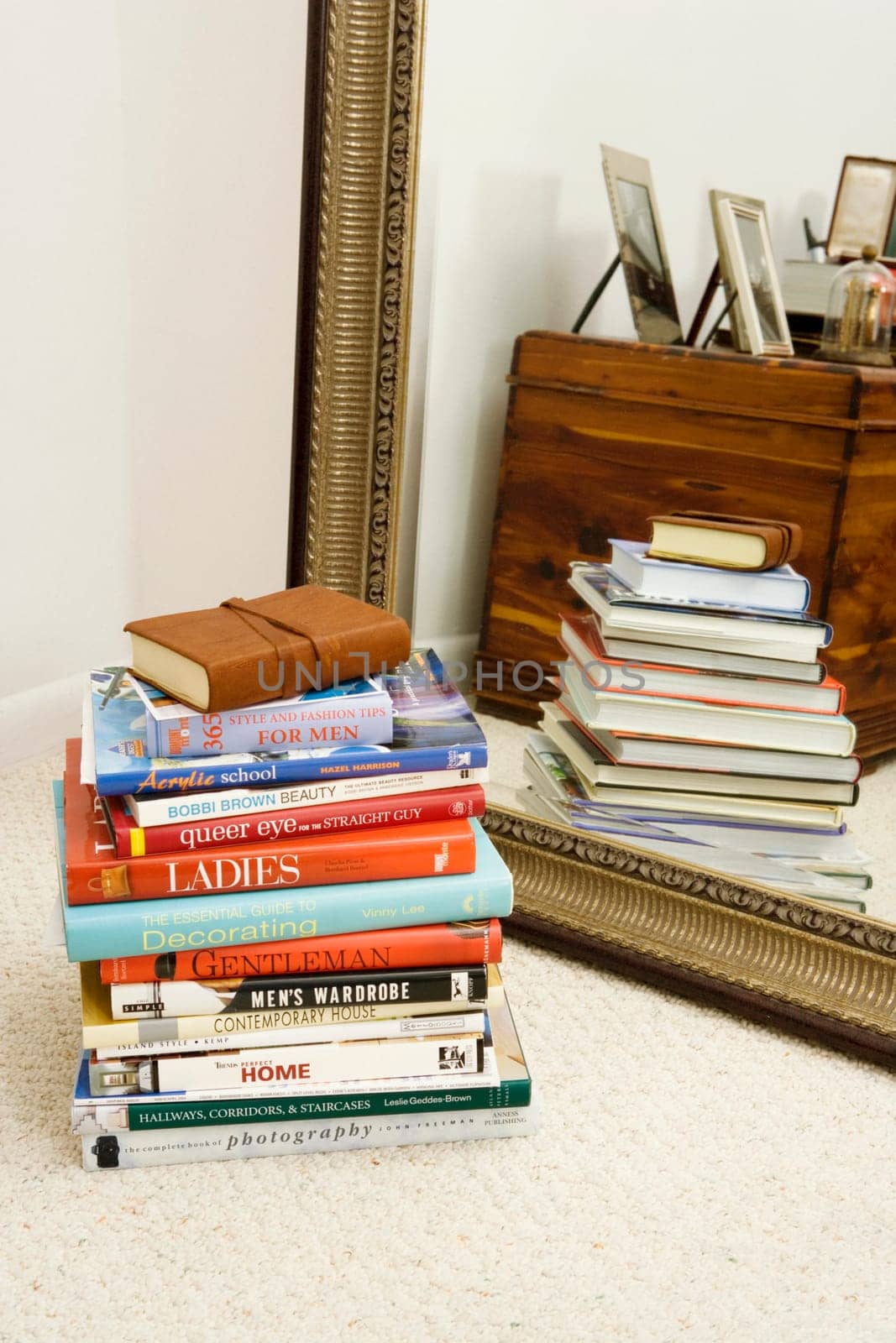 Stack of books in front of a mirror