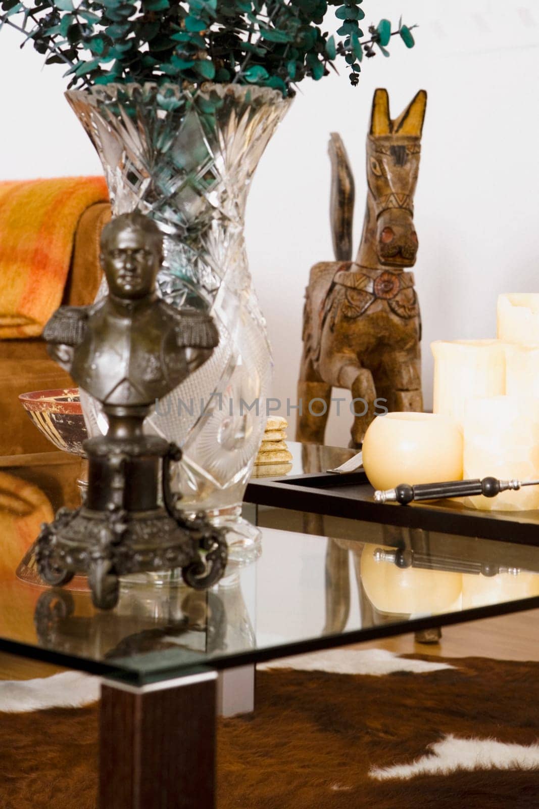 Candles with a vase and a figurine on a coffee table with in a living room
