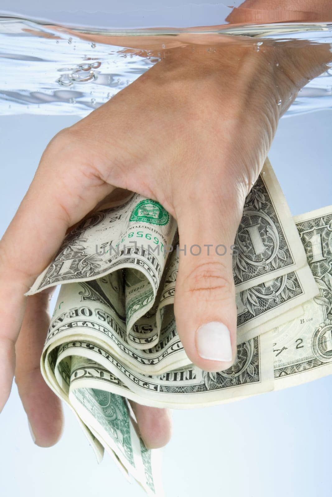 Close_up of a personŽs hand holding paper currency in water