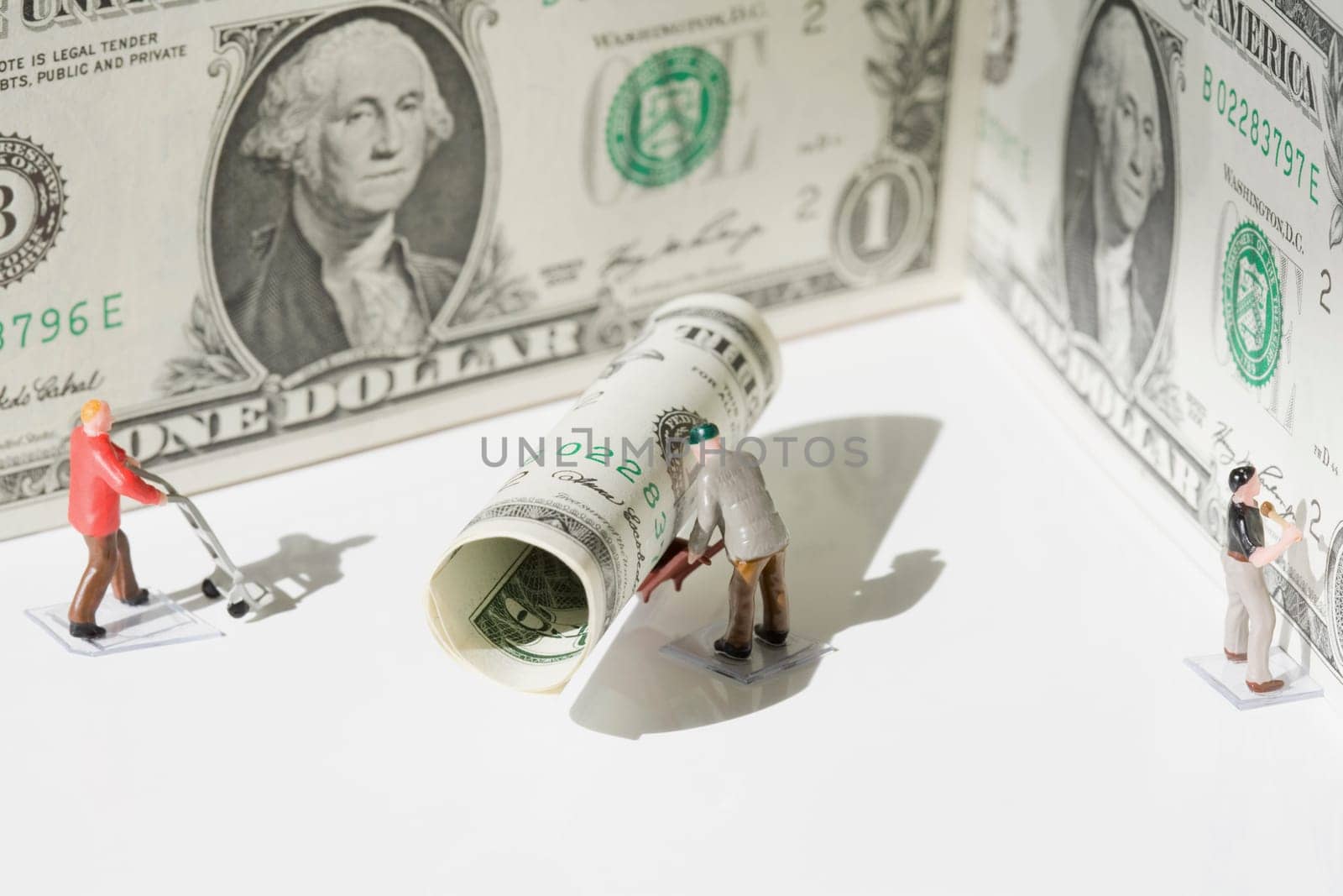 Figurines of manual workers with US dollar bills