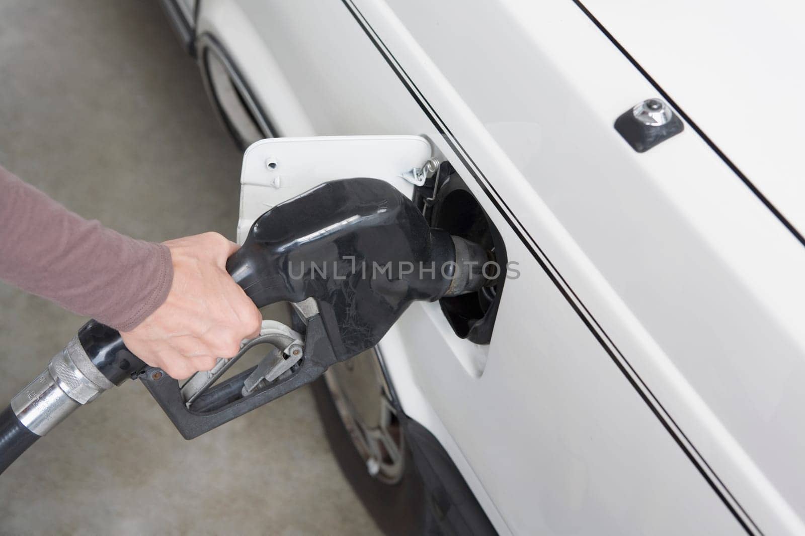 Woman refueling a car at a gas station