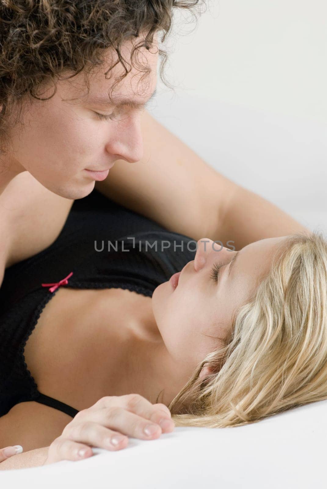 Close_up of a young couple romancing on the bed