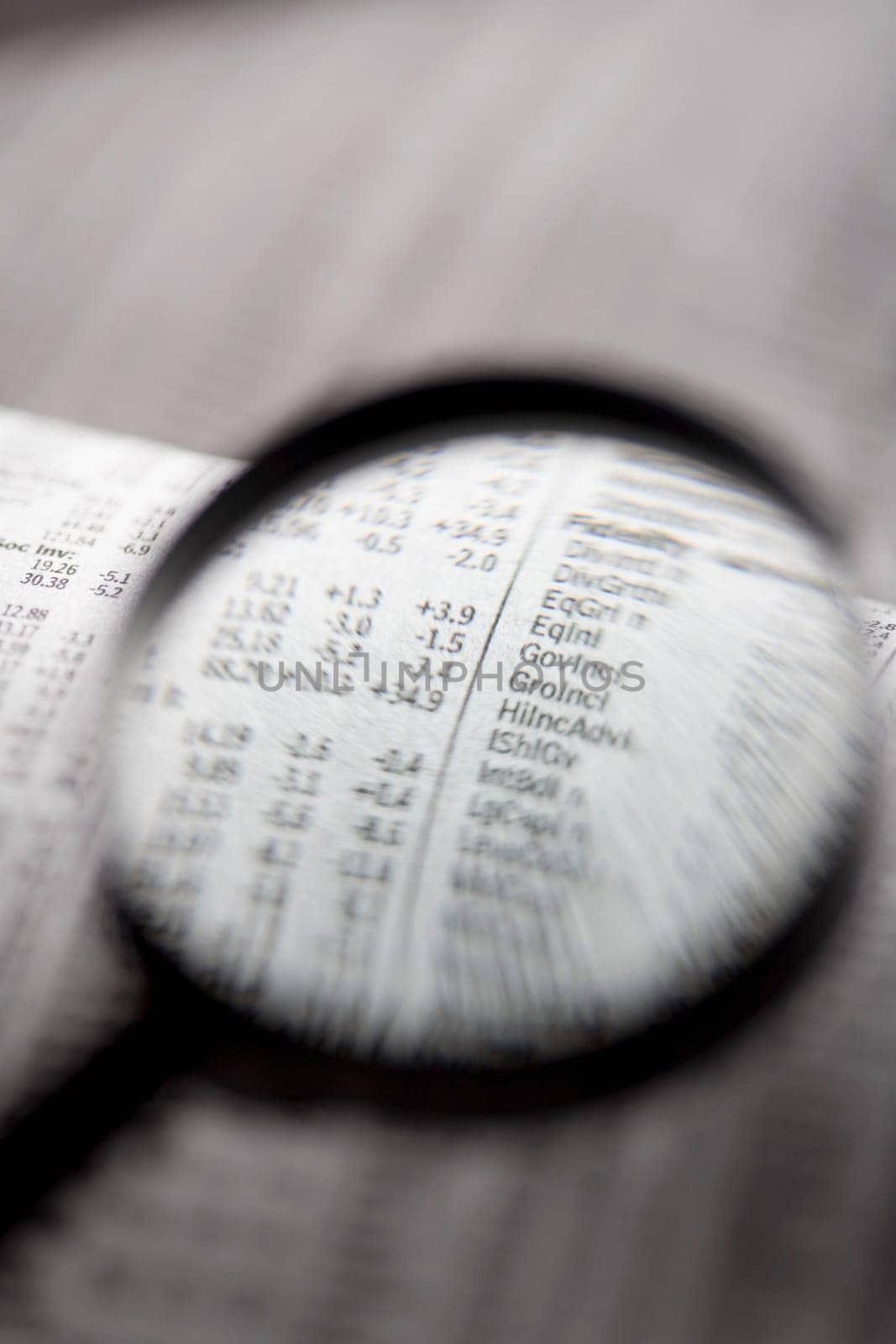 Close_up of a financial newspaper and a magnifying glass