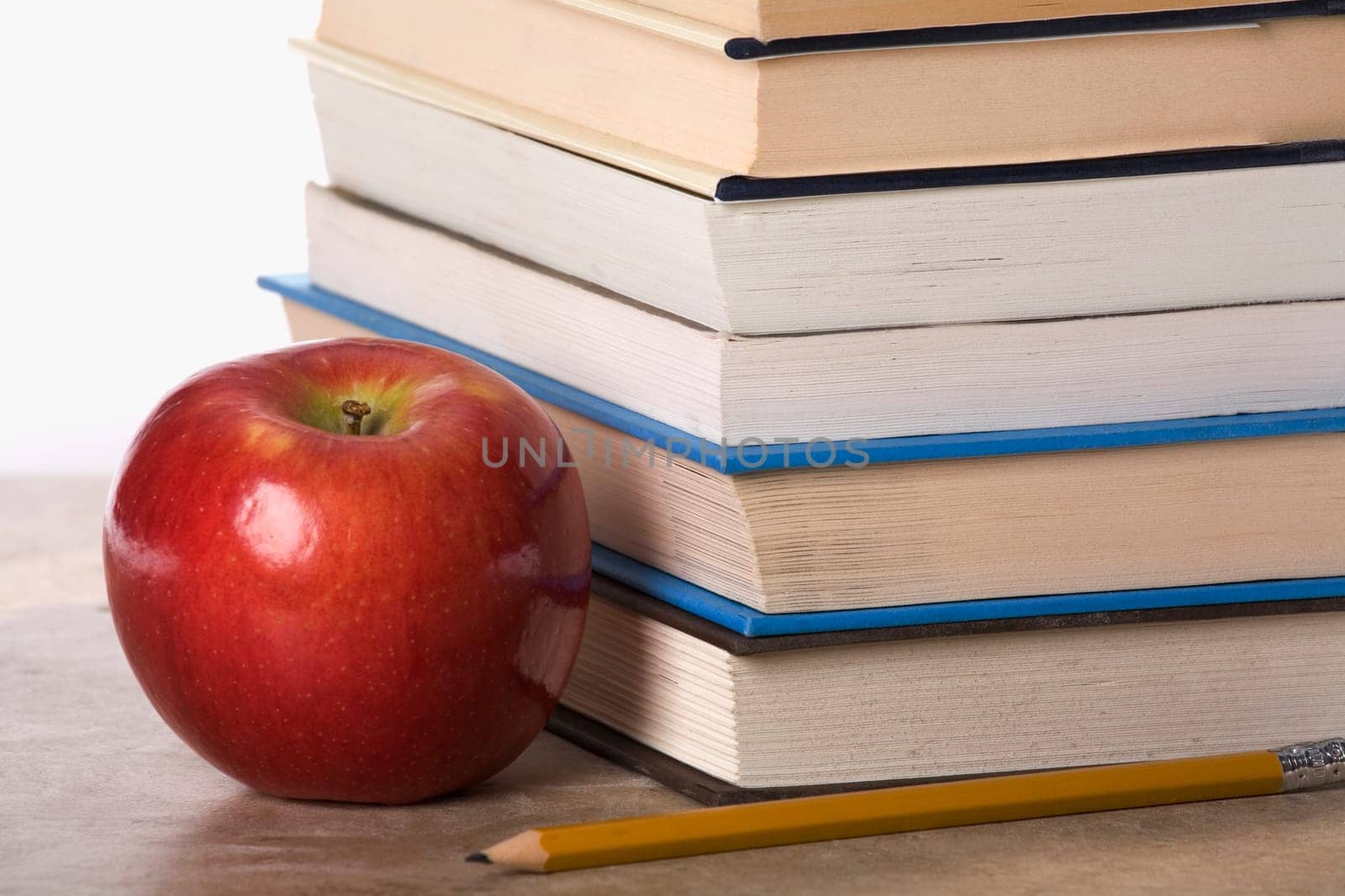 Close-up of an apple near a stack of books